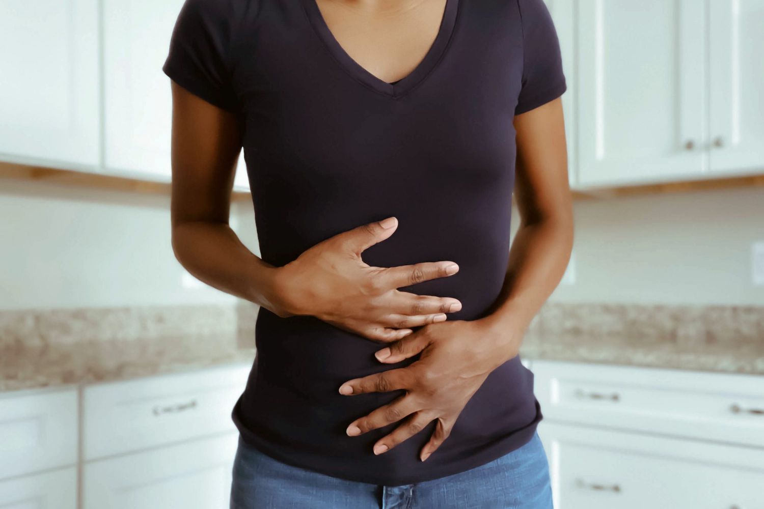woman with stomach pain touching stomach