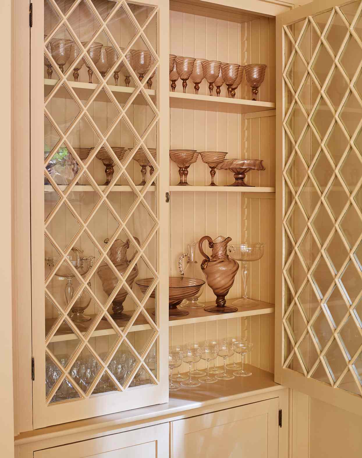 pink venetian glassware showcased in cabinet