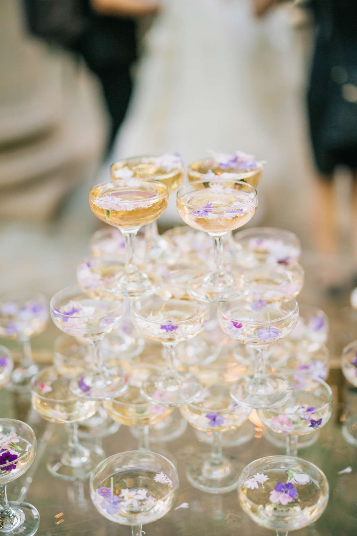 champagne tower with purple flowers in the coupe glasses