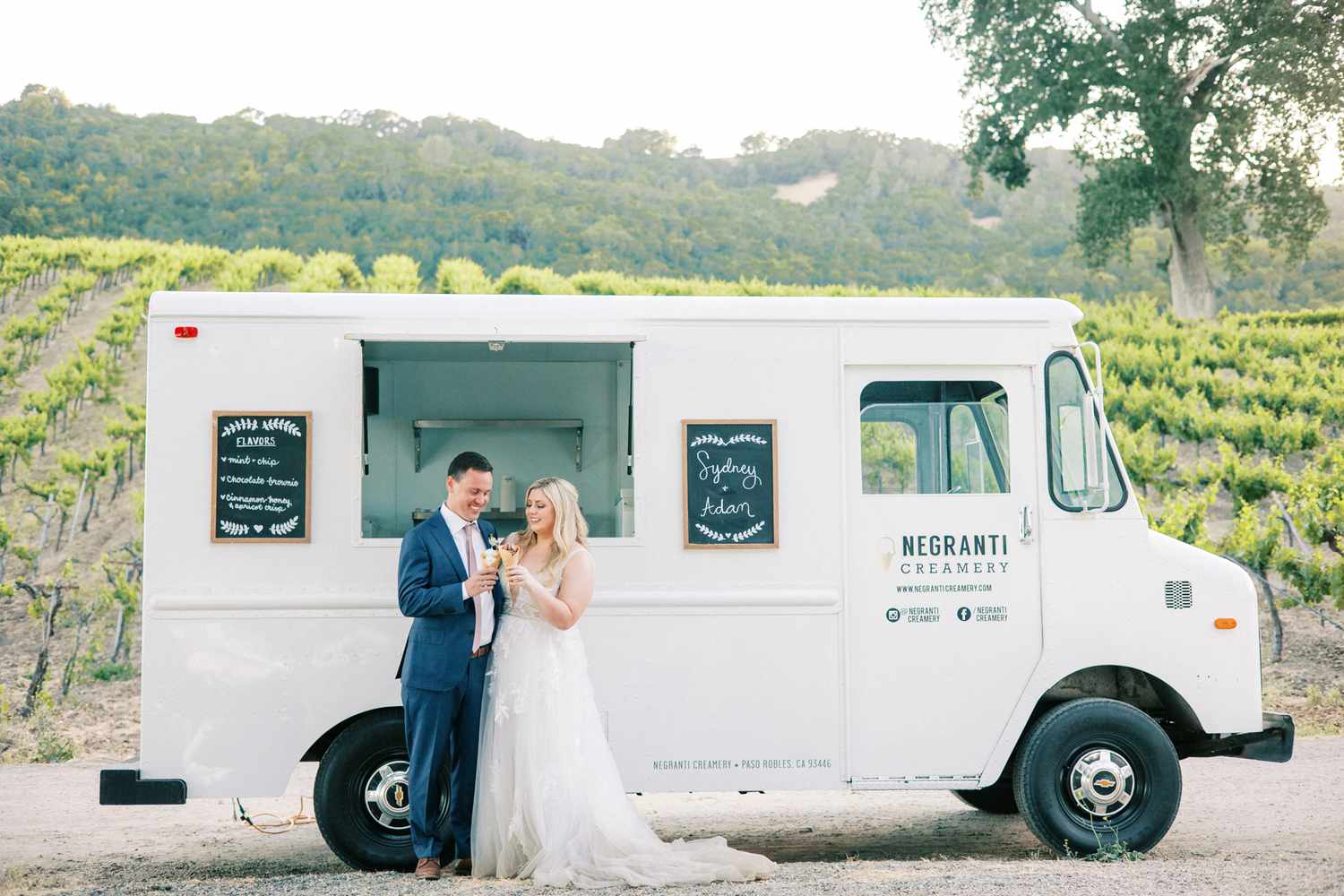 couple holding ice cream cones by creamery truck