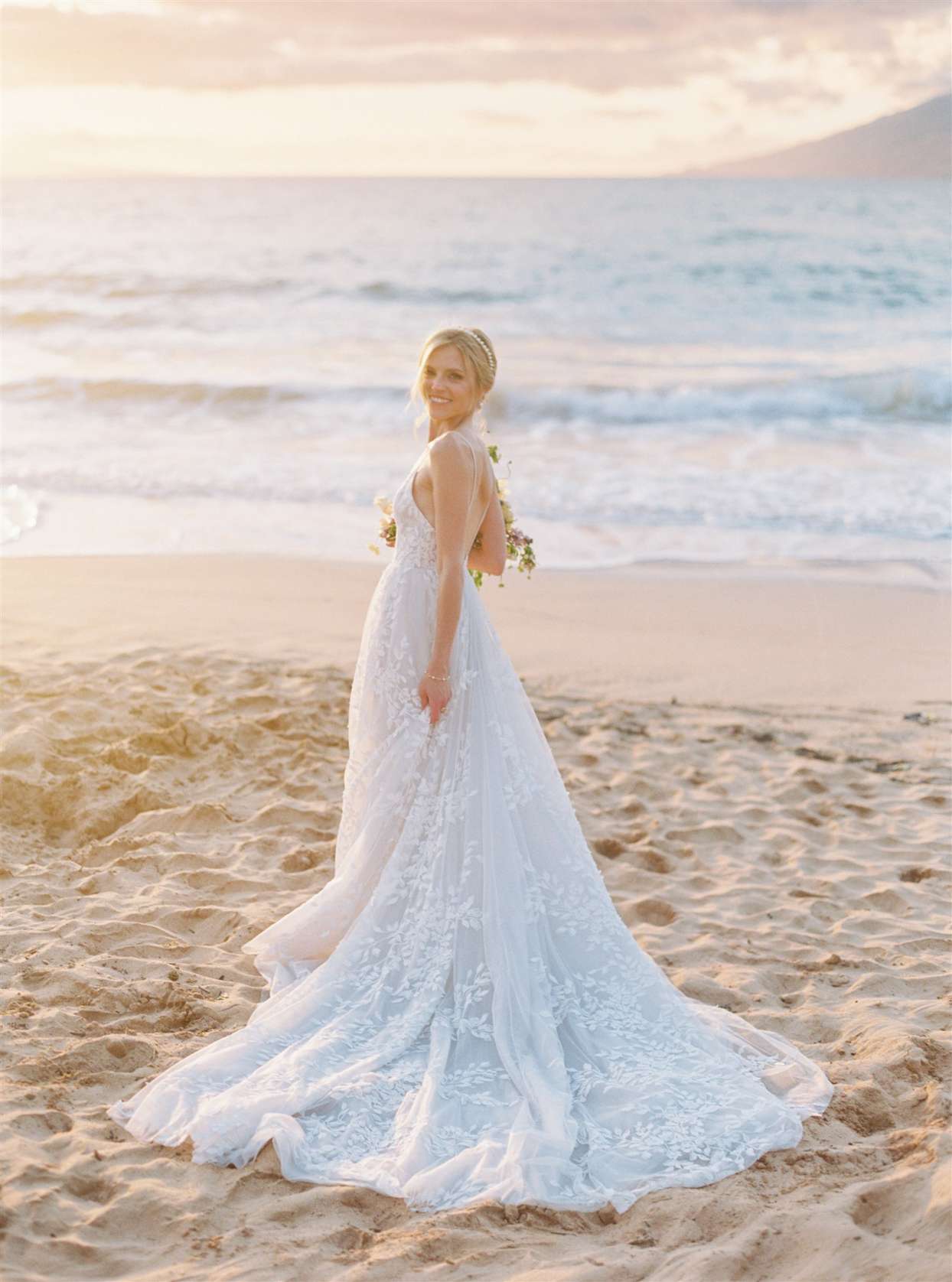 bride posing on beach at sunset