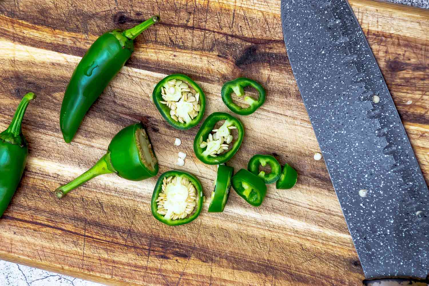 sliced jalapenos on wood cutting board