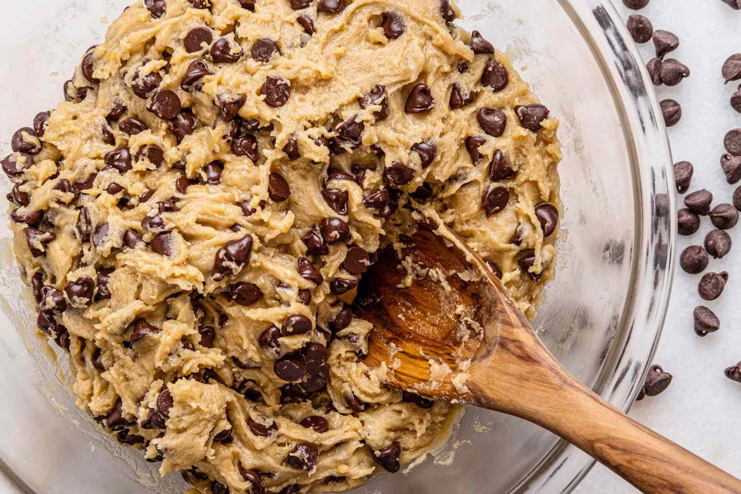 mixing chocolate chip cookie dough in glass bowl