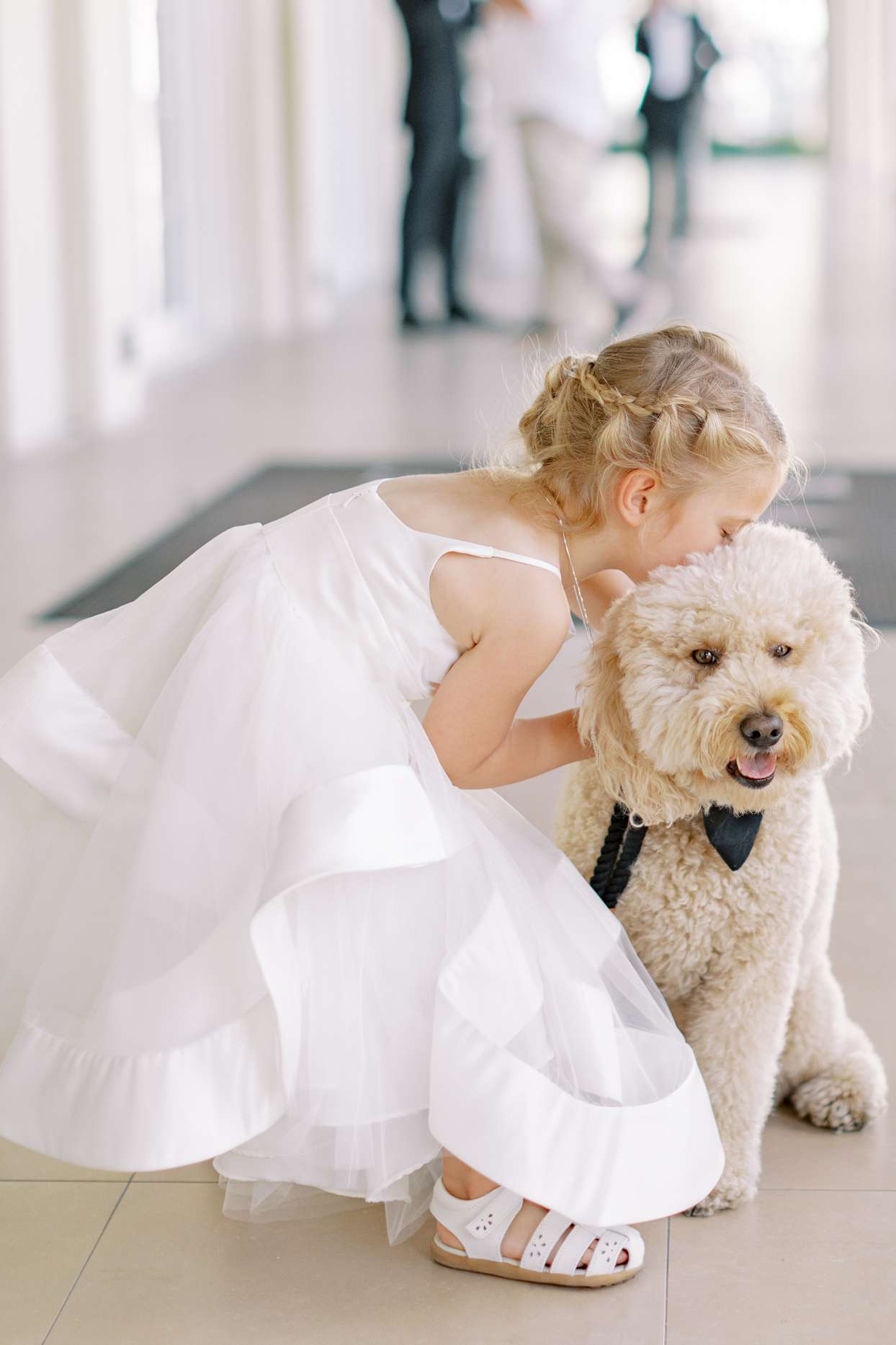 flower girl hugging dog at wedding