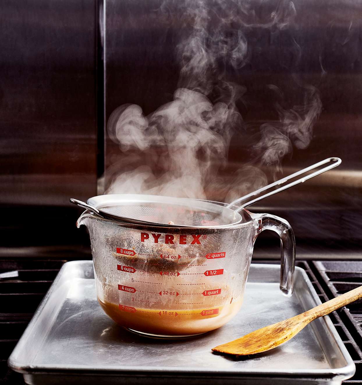 steaming gravy in pyrex cup strain through fine sieve