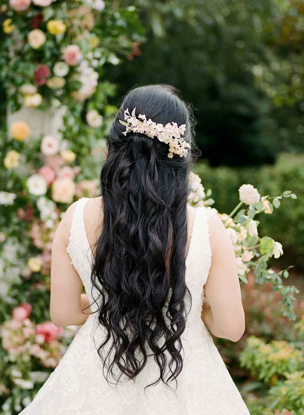 bride's curly dark hair with pastel pink floral headpiece