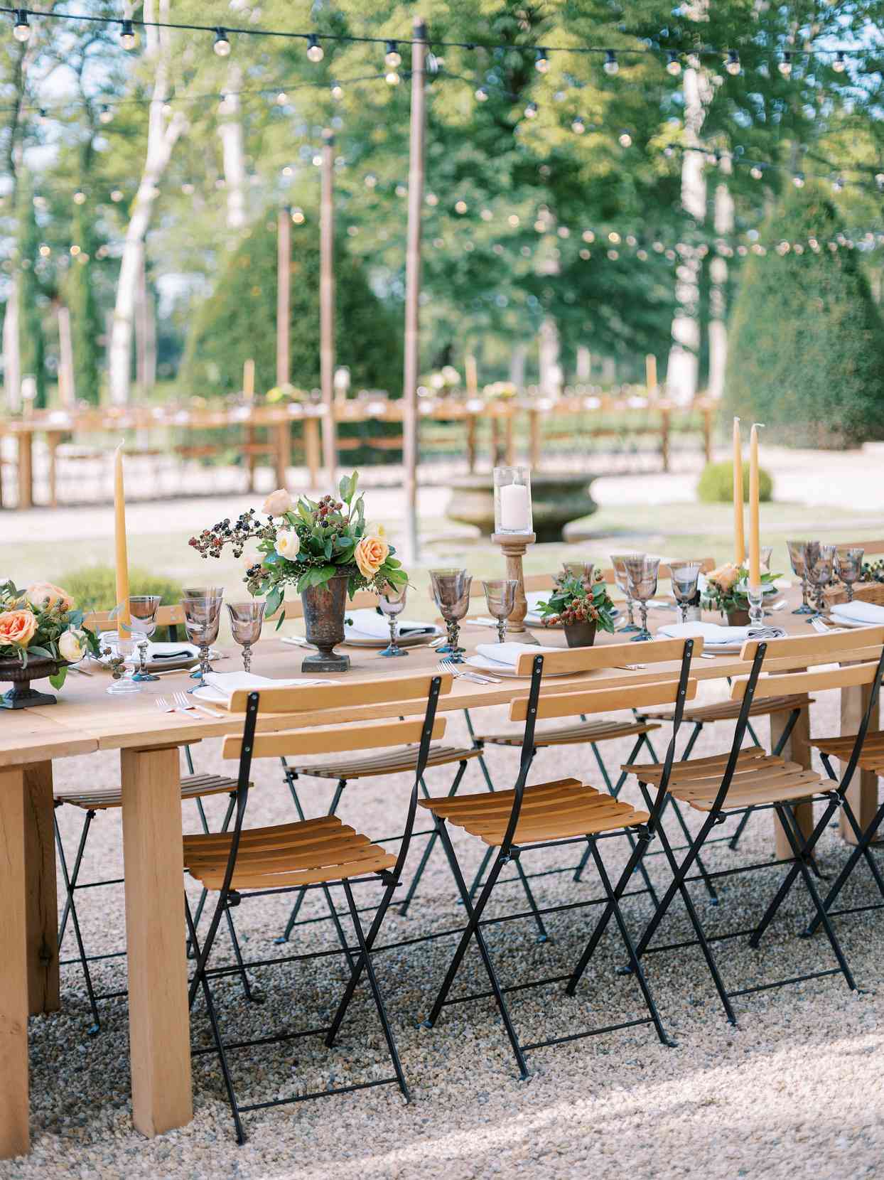 long wooden tables with matching chairs rehearsal dinner