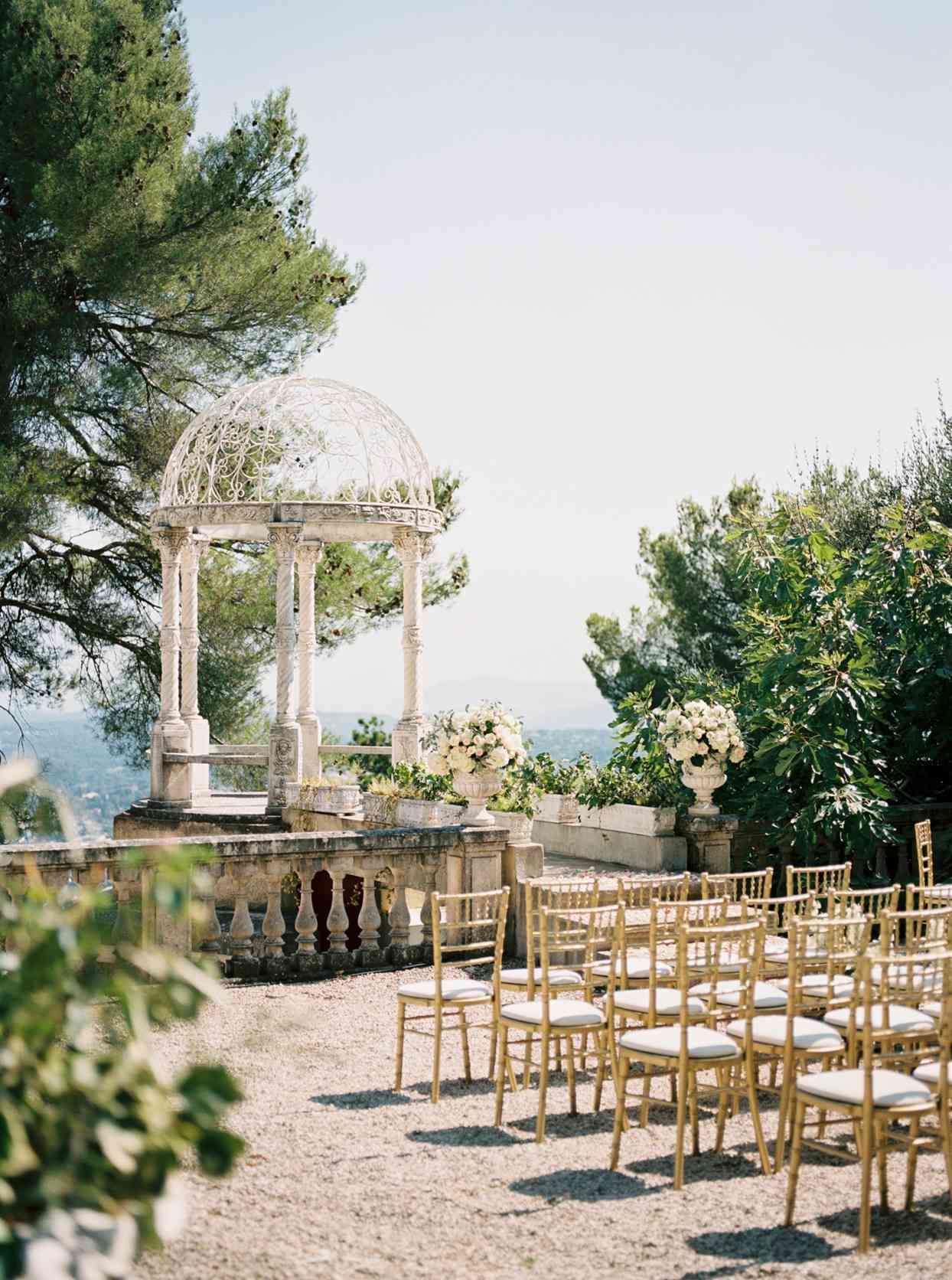 wedding ceremony set up facing white stone gazebo