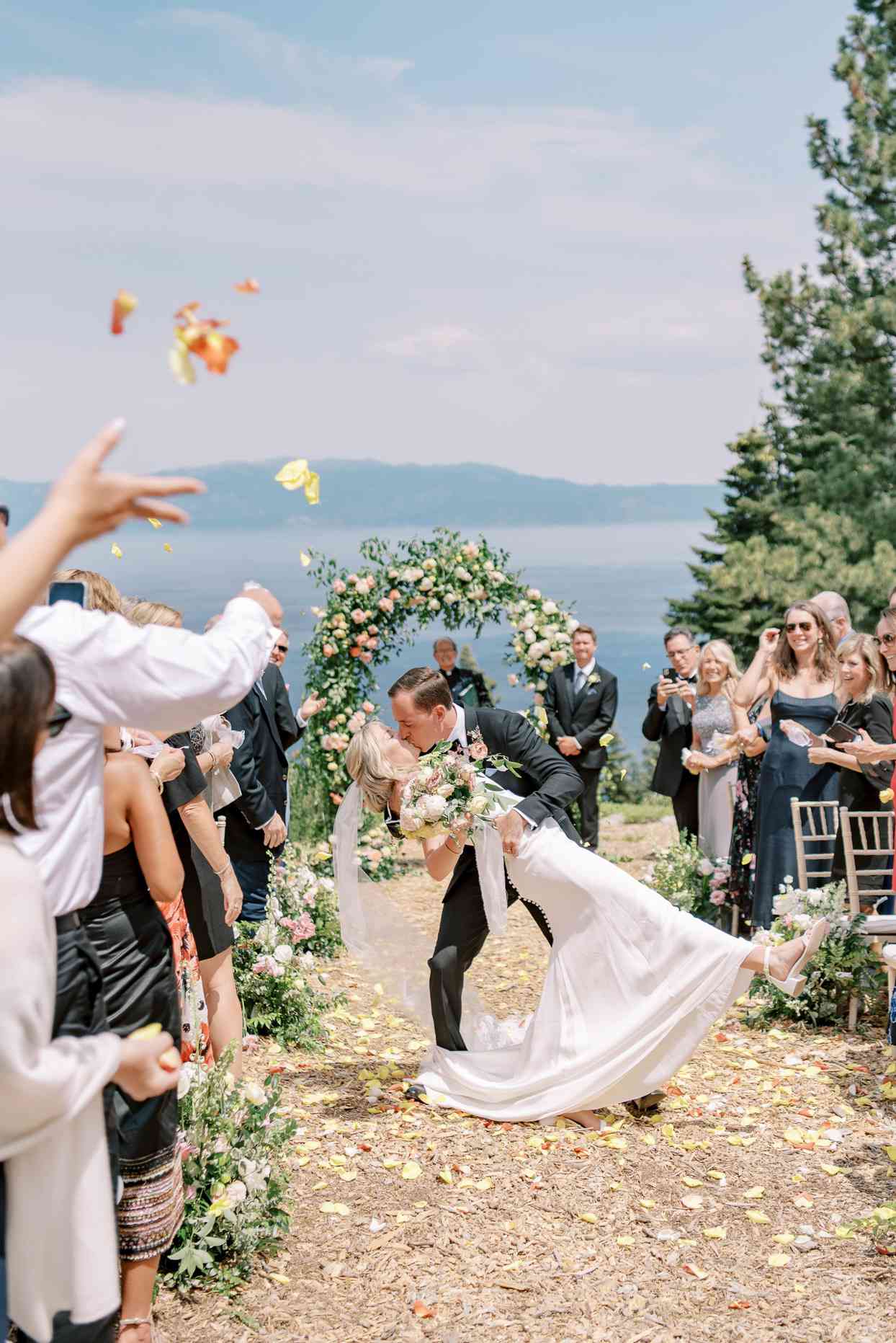 groom dipping bride of kiss during outdoor ceremony recessional