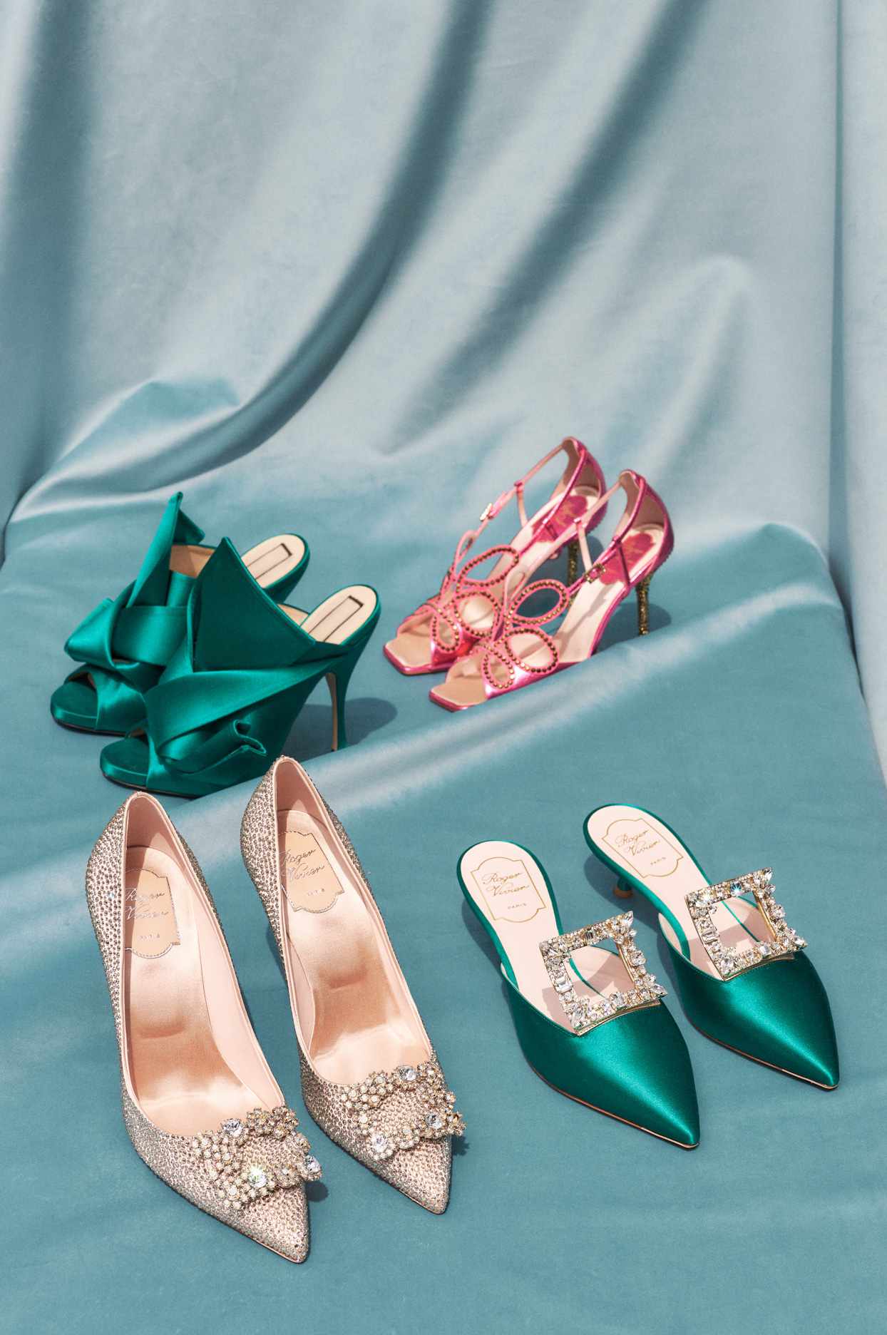 four pairs of sparkly pumps against a blue backdrop