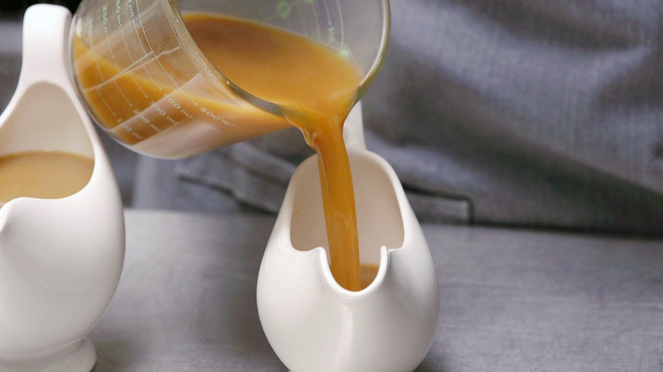 pouring gravy from measuring cup into serving bowl