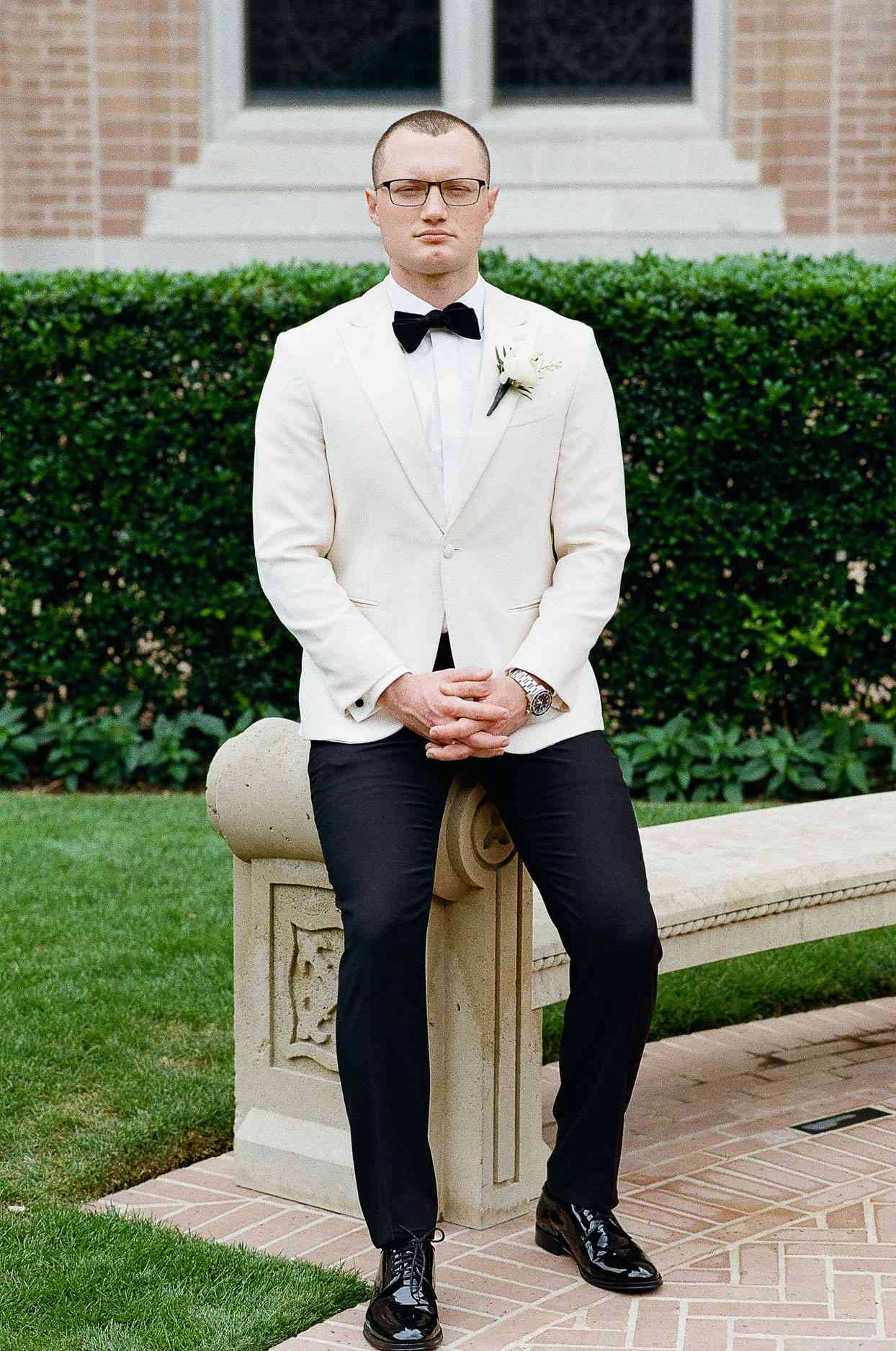 groom in black and white tux with bowtie