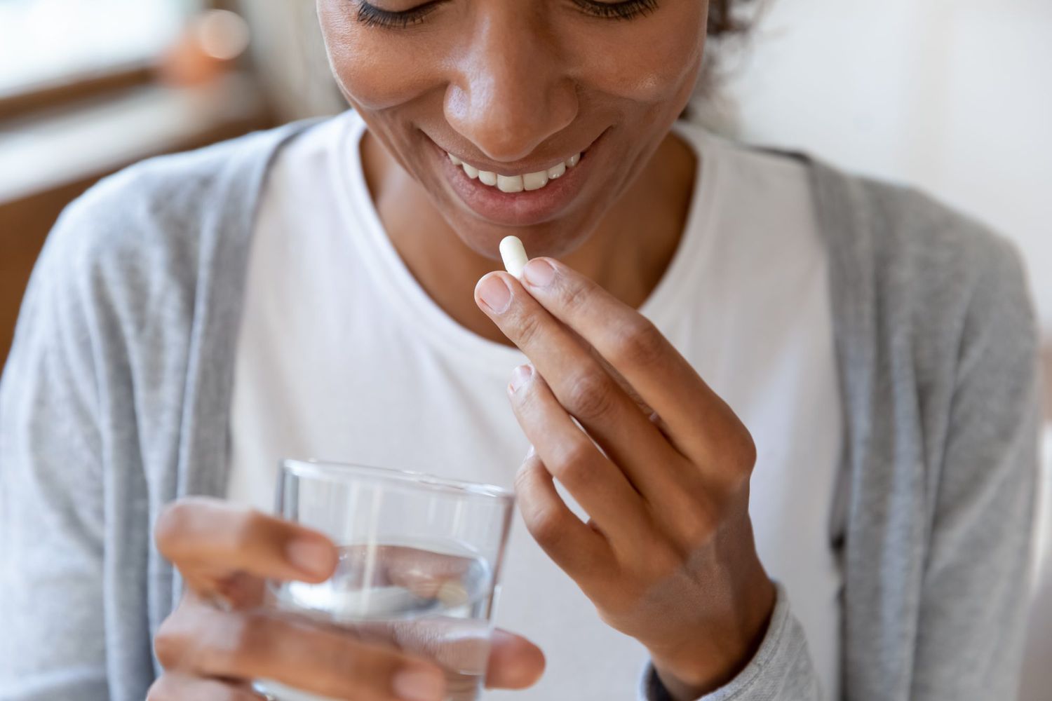smiling woman taking a vitamin