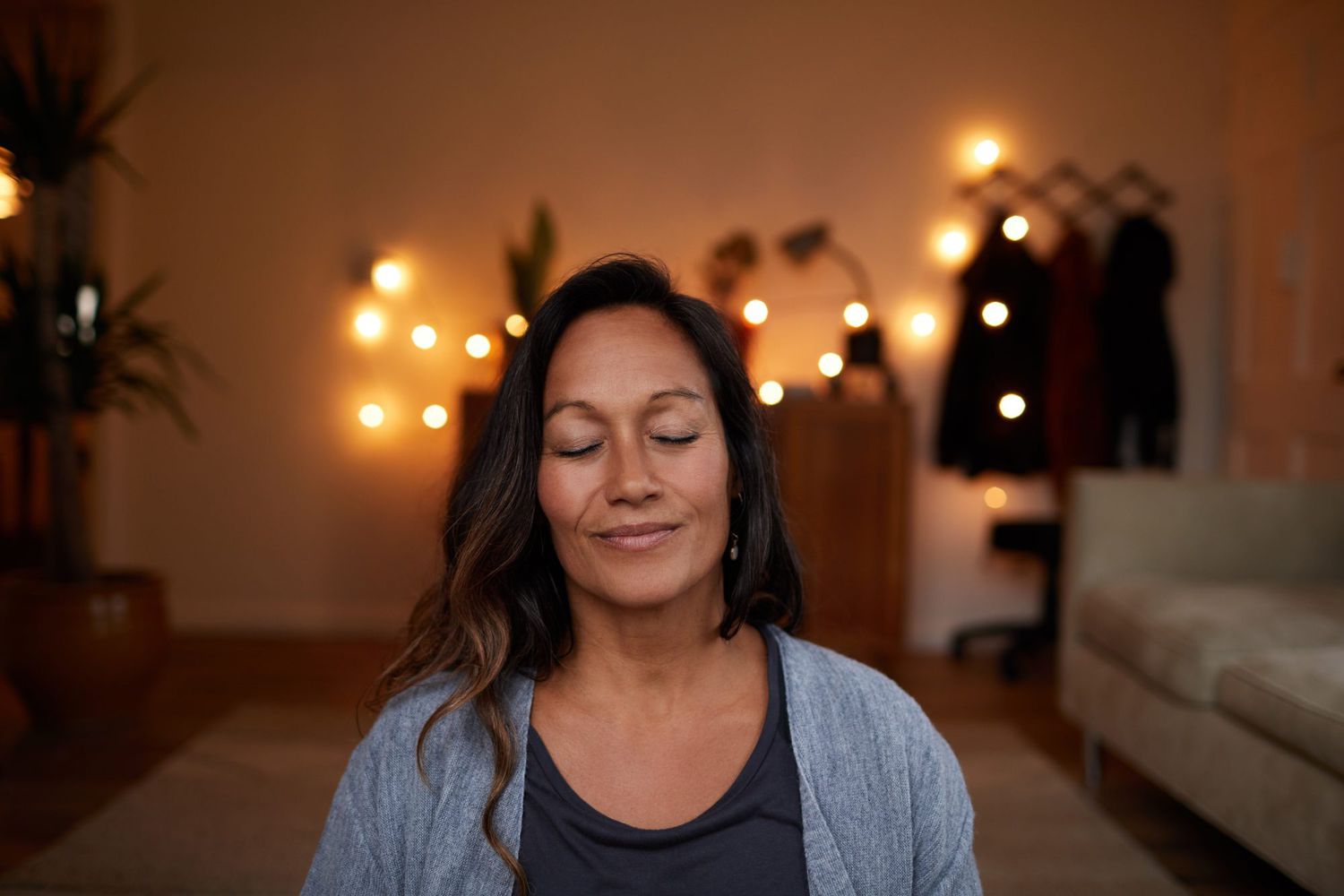 woman meditating at night in home