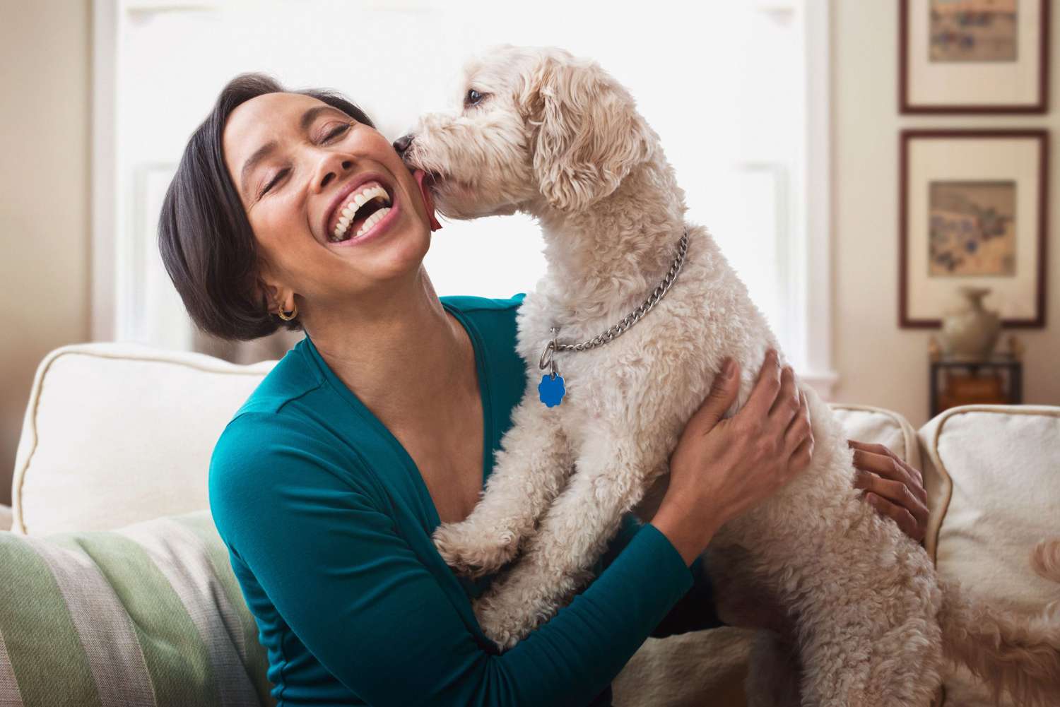 smiling woman with dog licking her face