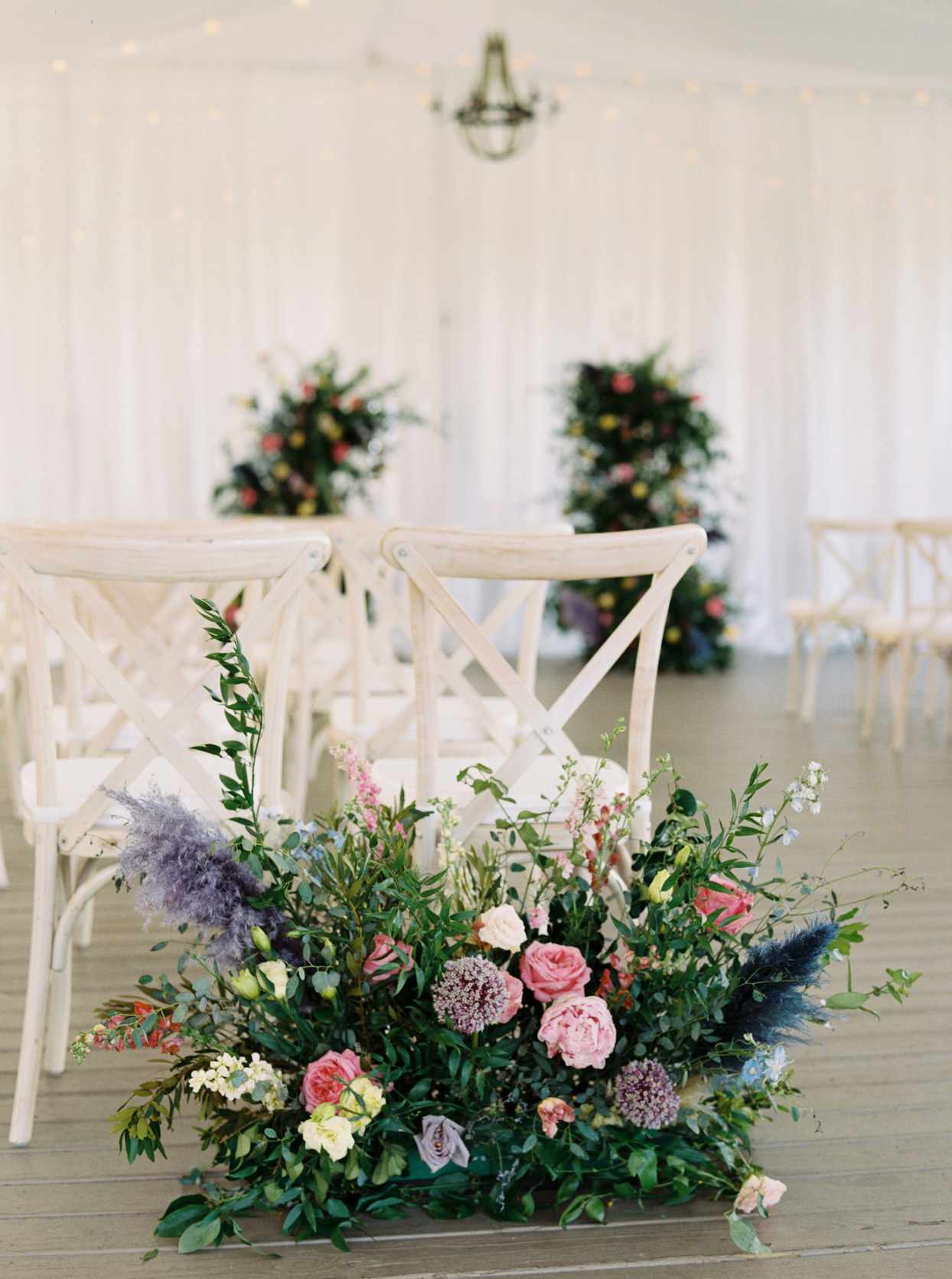 wedding ceremony aisle markers comprised of colorful flowers and greenery