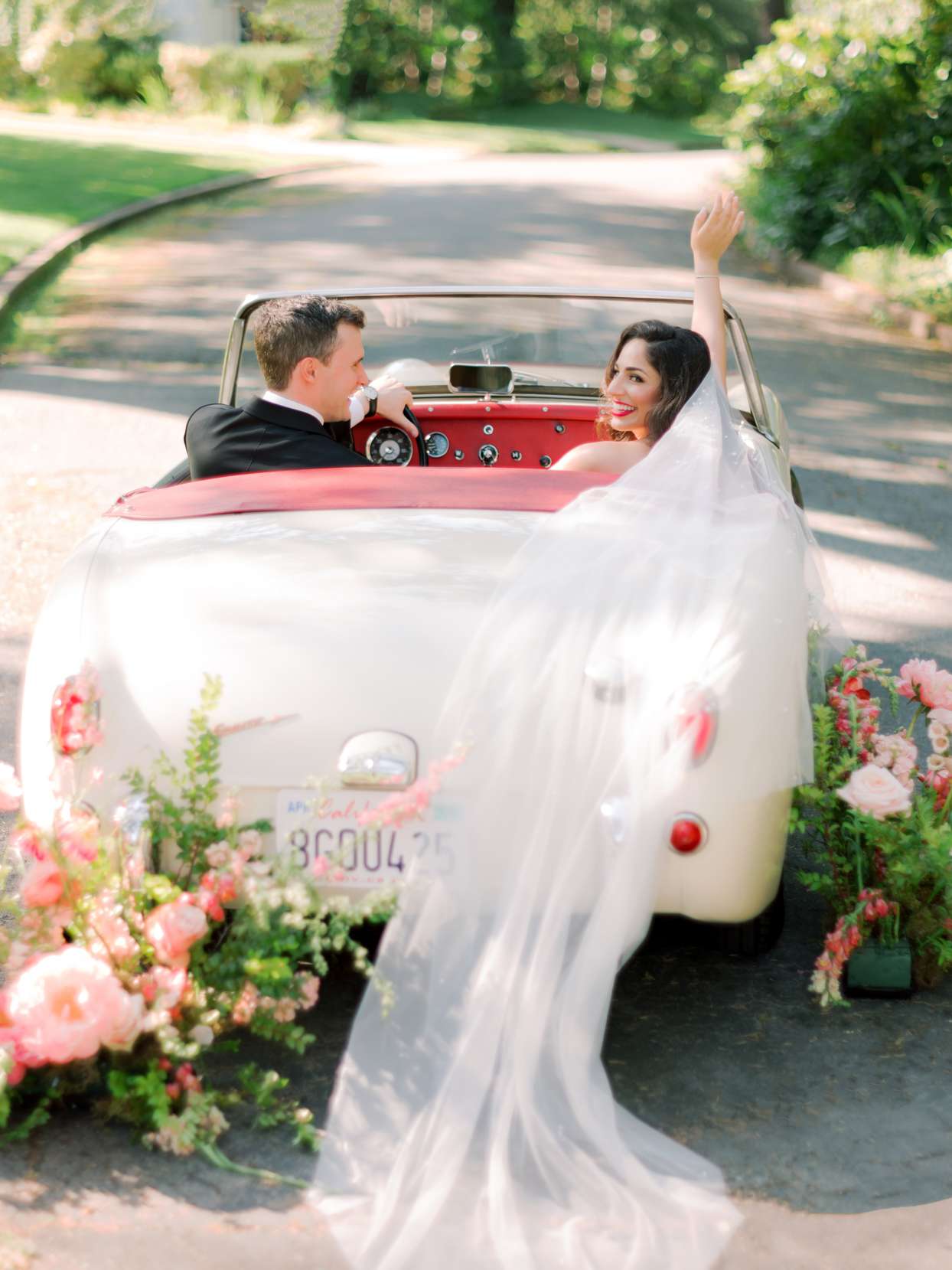 bride and groom in vintage white car