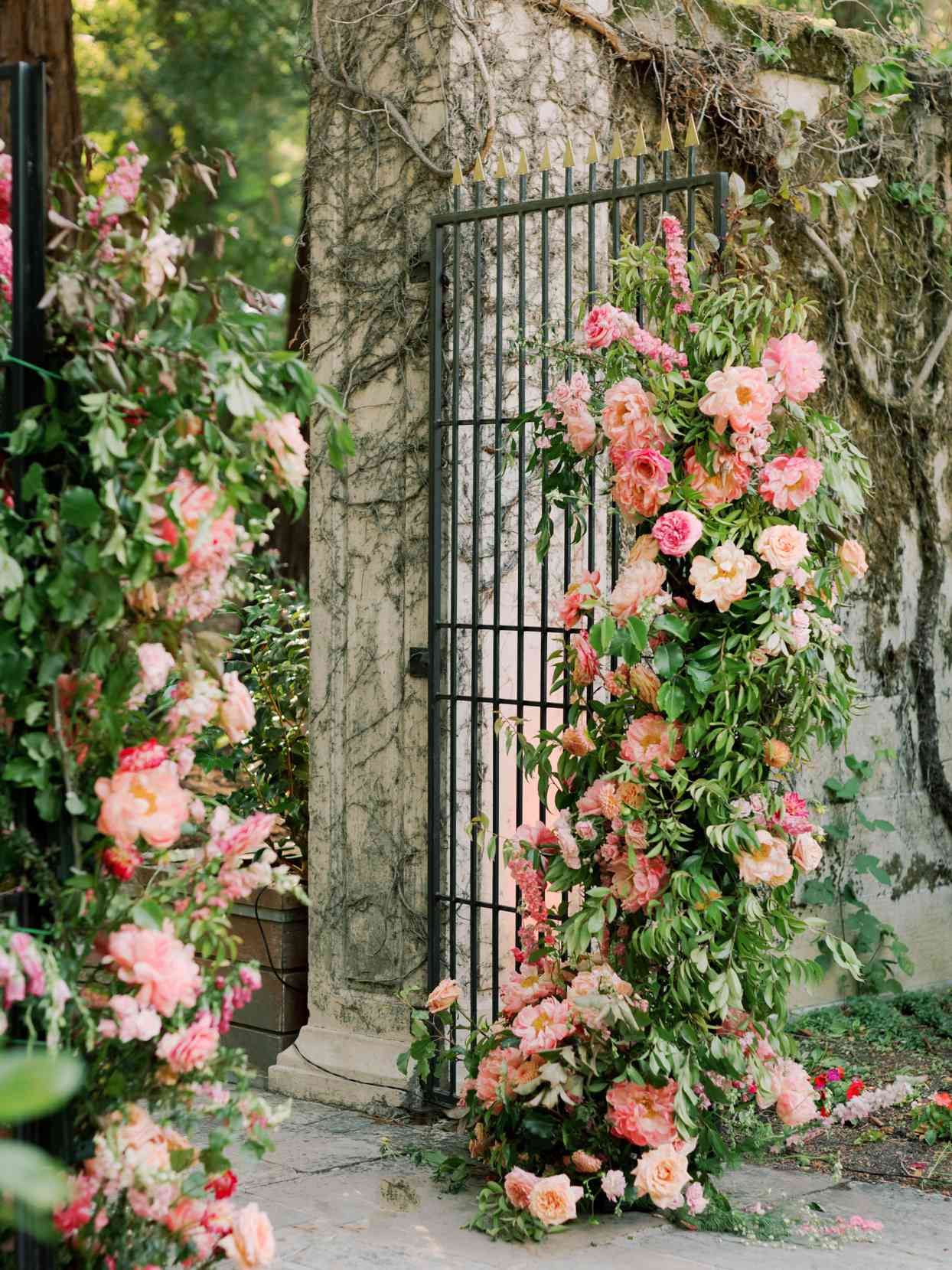black iron wedding gate with pink floral decor