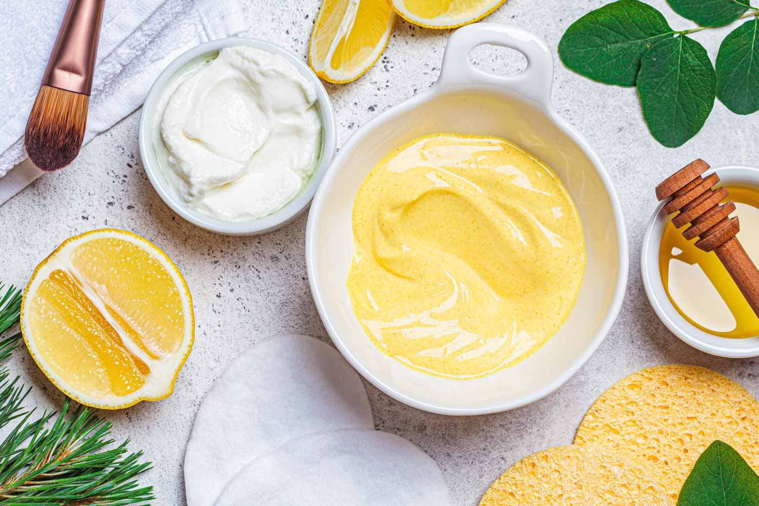 Preparation of turmeric face mask with honey and yogurt in white bowl