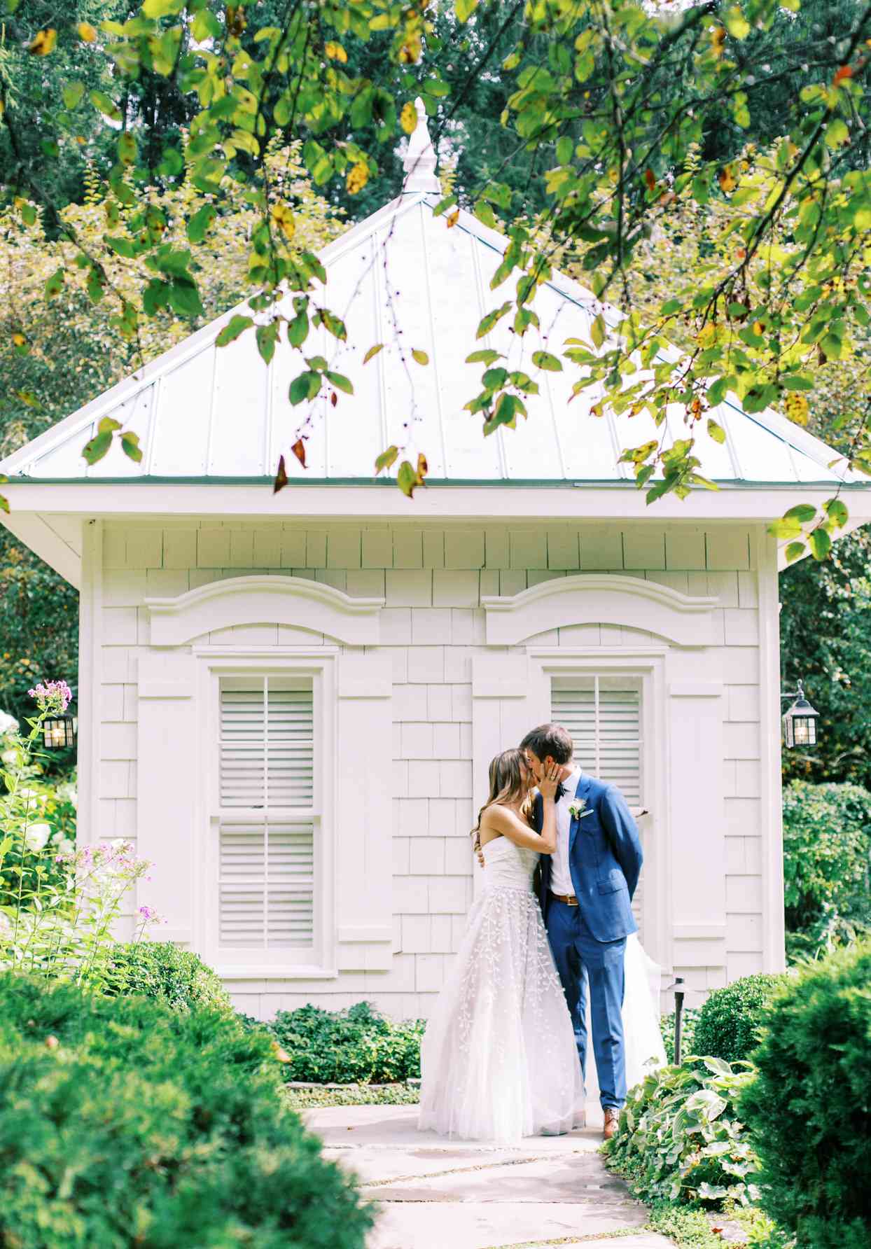 wedding couple kissing on stone path in garden