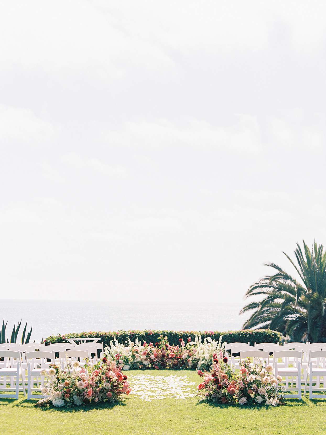 outdoor wedding ceremony with white chairs