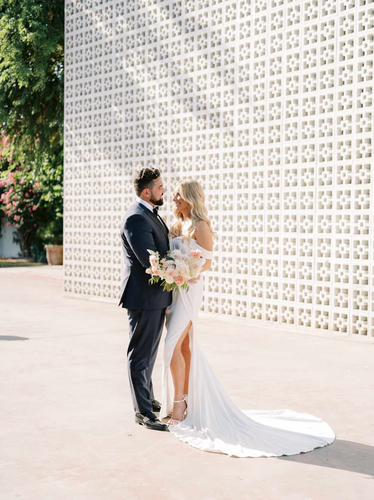 bride and groom next to geometric wall