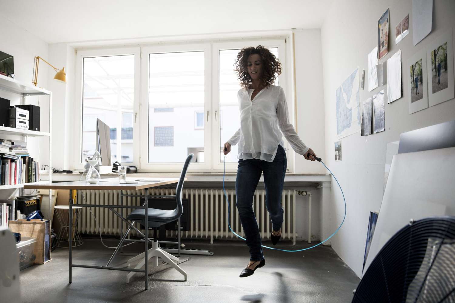 Businesswoman in office skipping rope