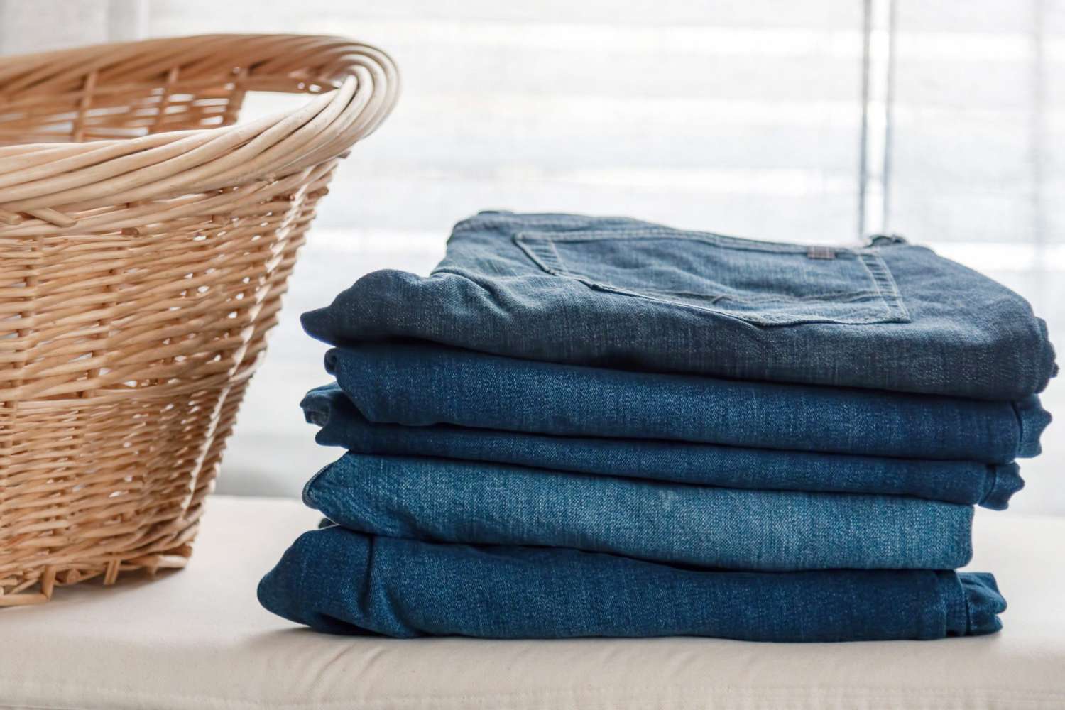folded blue jeans on ironing board