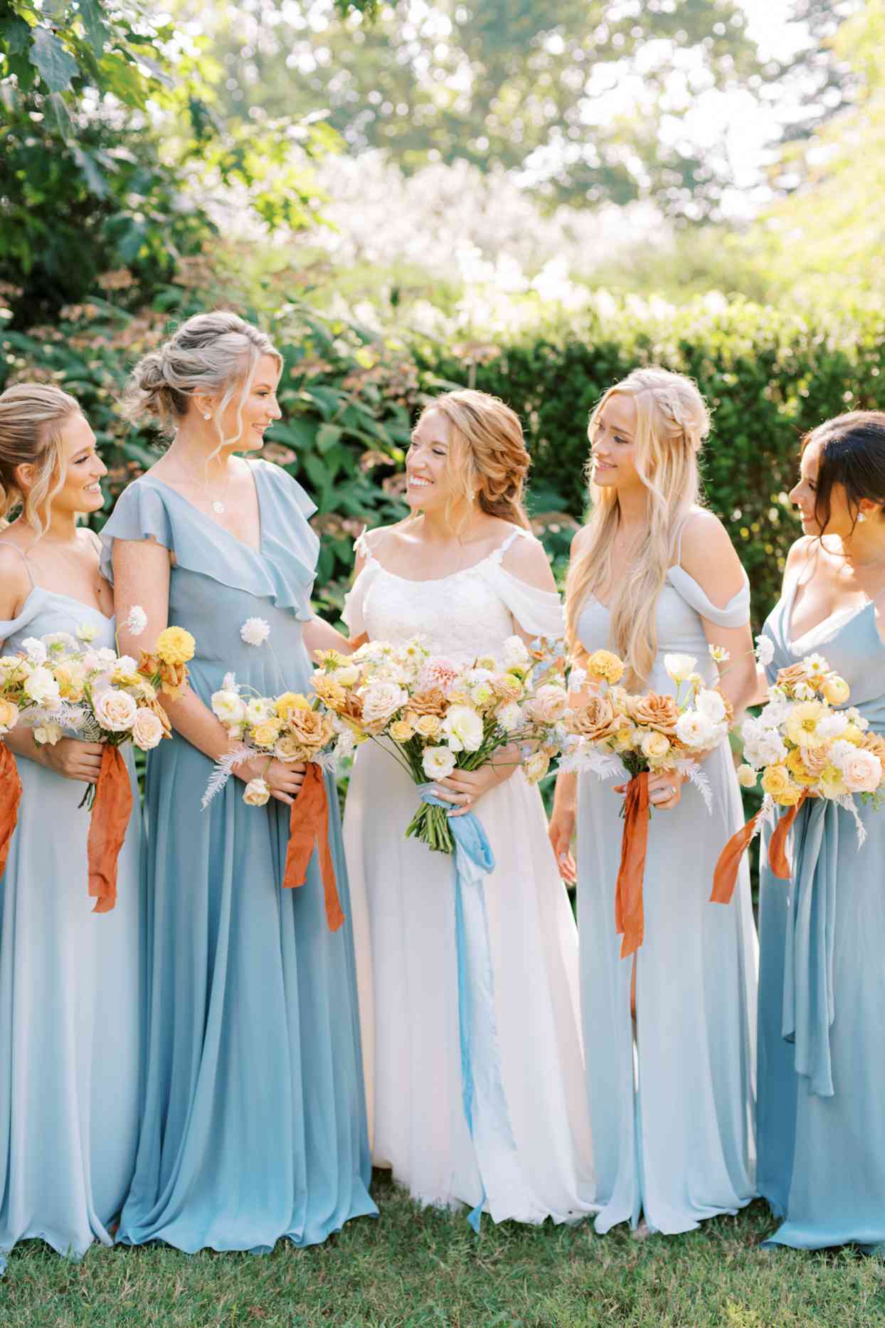bridesmaids in pale blue summer dresses with bride