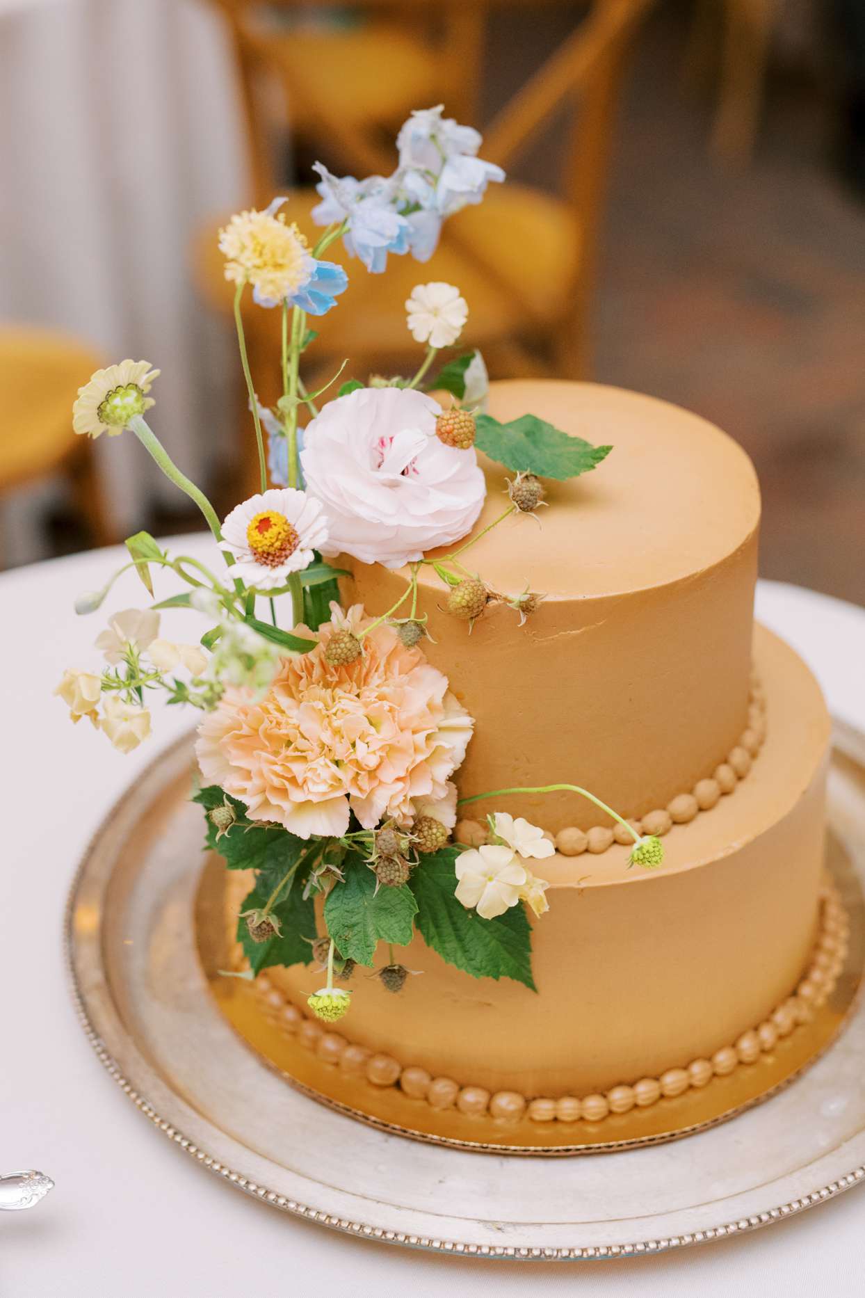 gold wedding cake with summer floral decoration