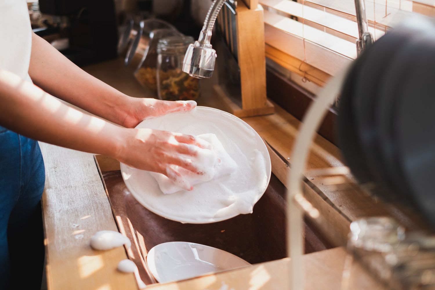 hand washing dishes with sponge