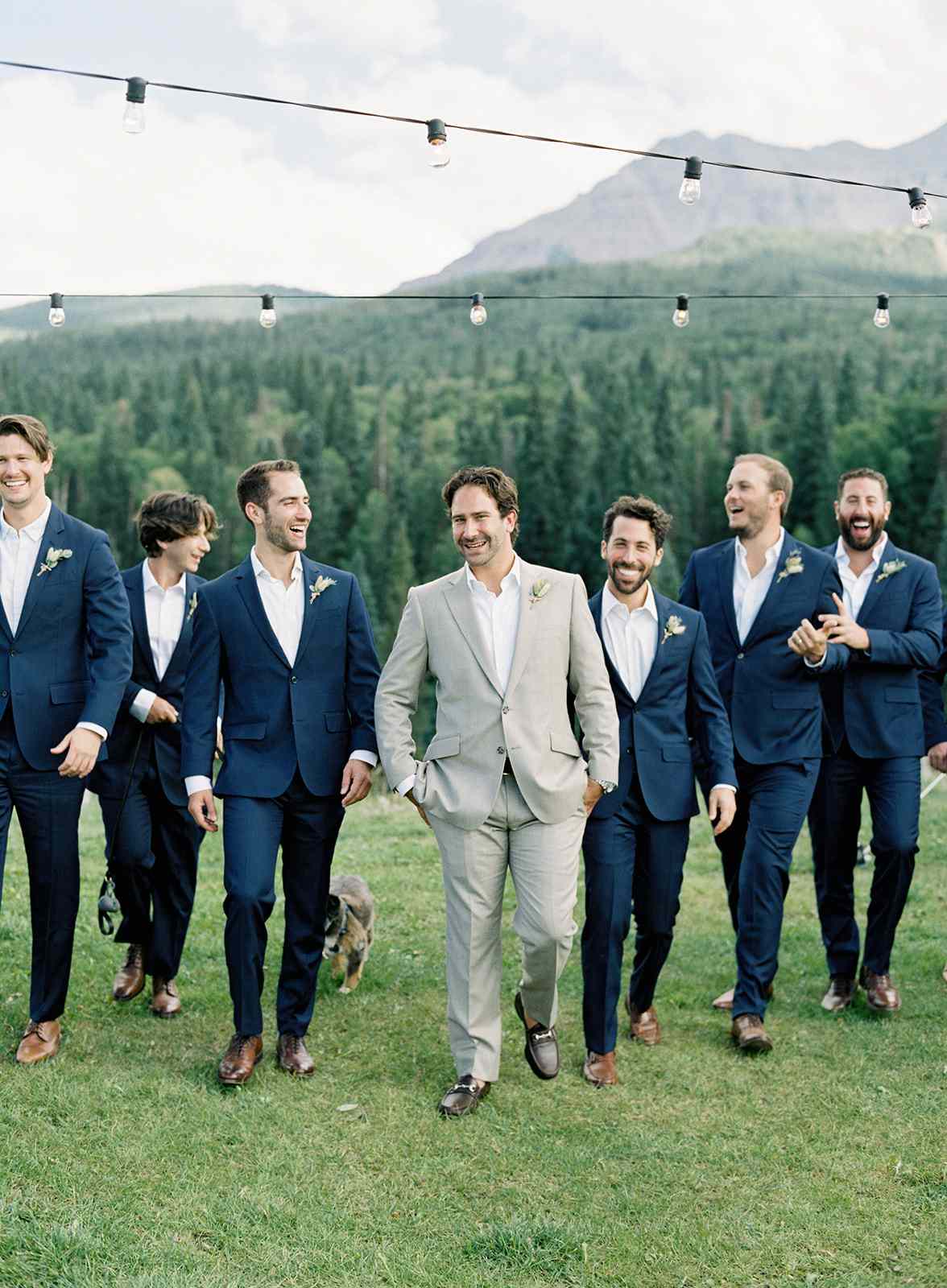 groom walking with groomsmen wearing navy suits