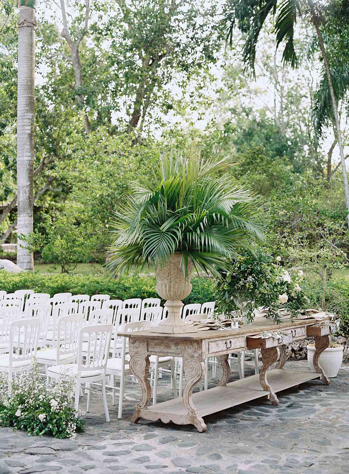 outdoor wedding ceremony with white chairs and fan station