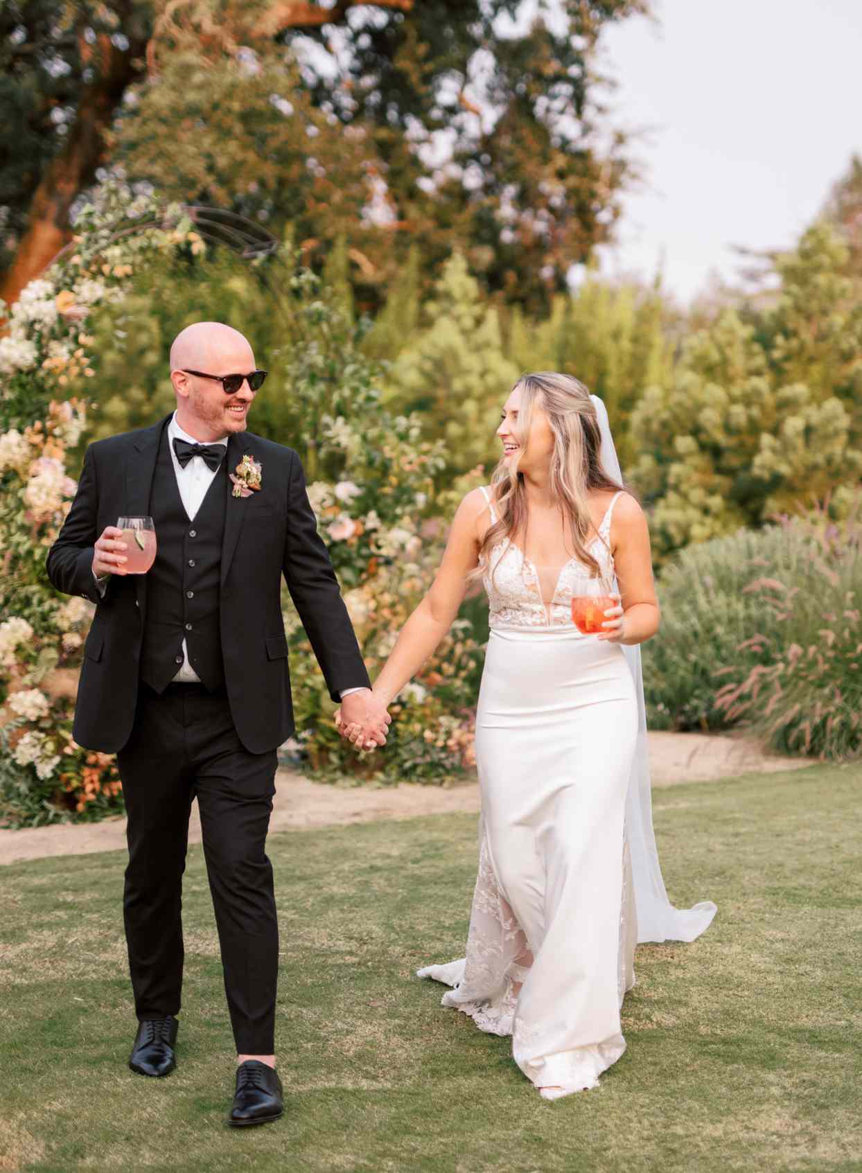 couple walking together holding wedding cocktails