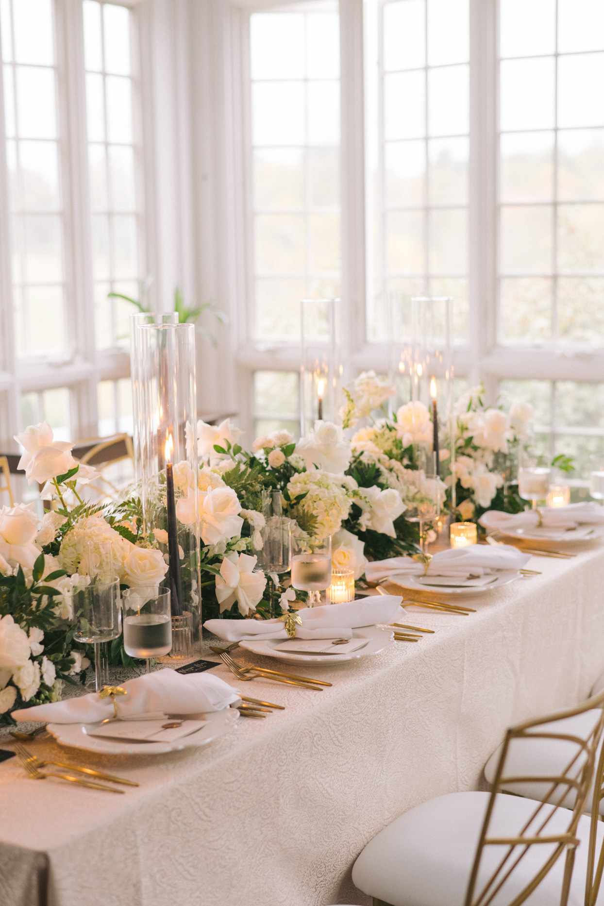 dinner reception table with white linens and gold accents