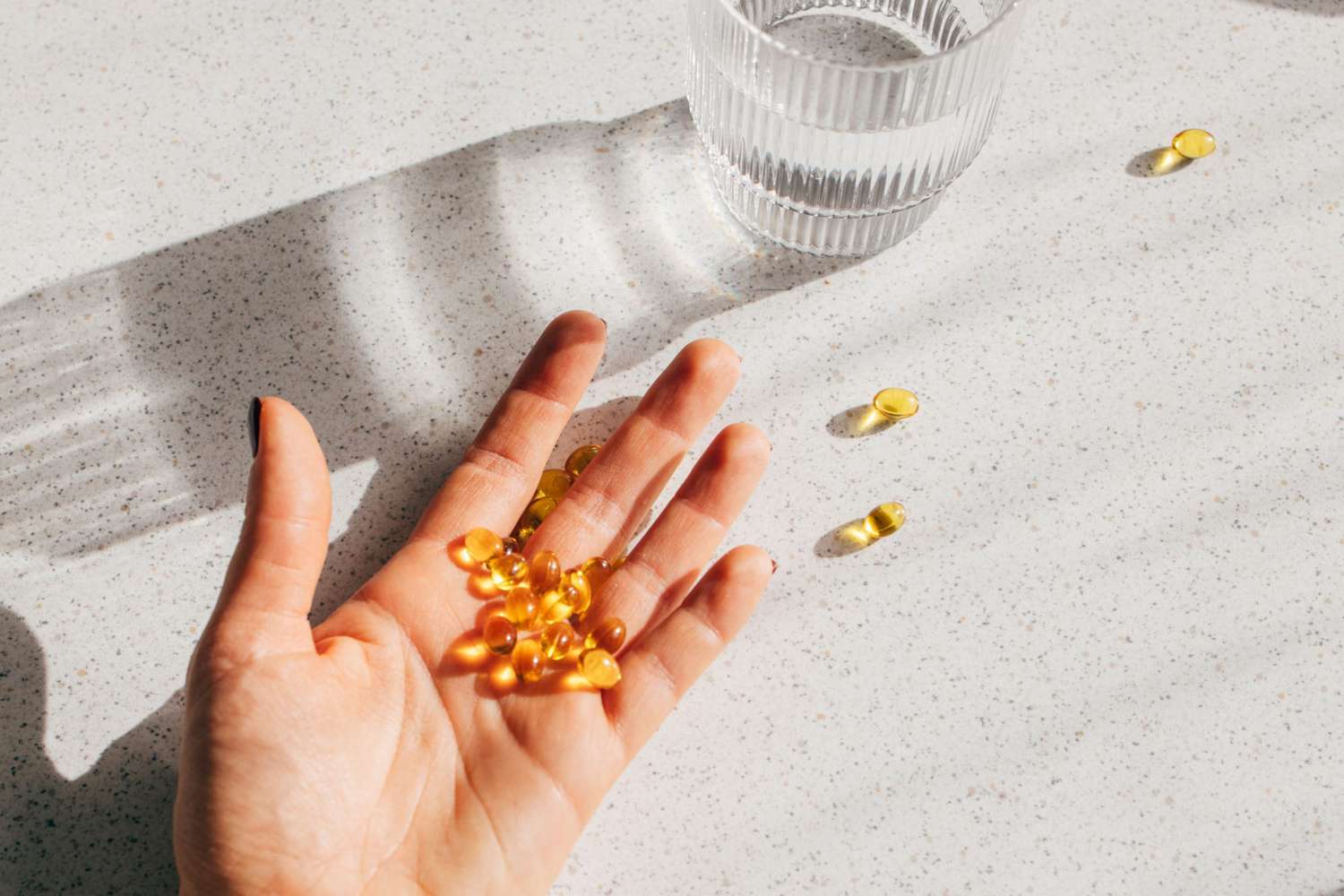 open hand holding vitamin d supplements
