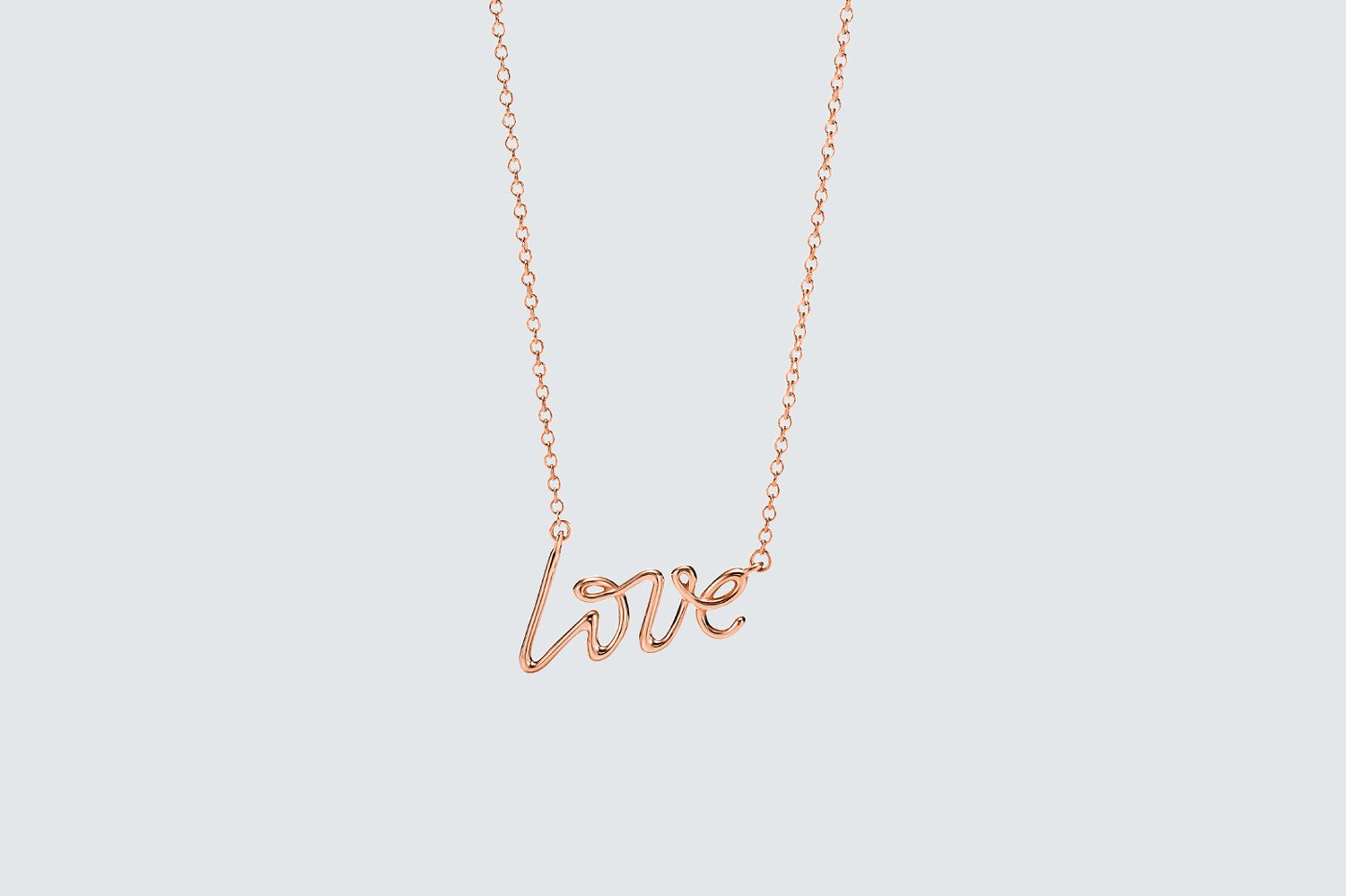 Rose gold necklace on solid background