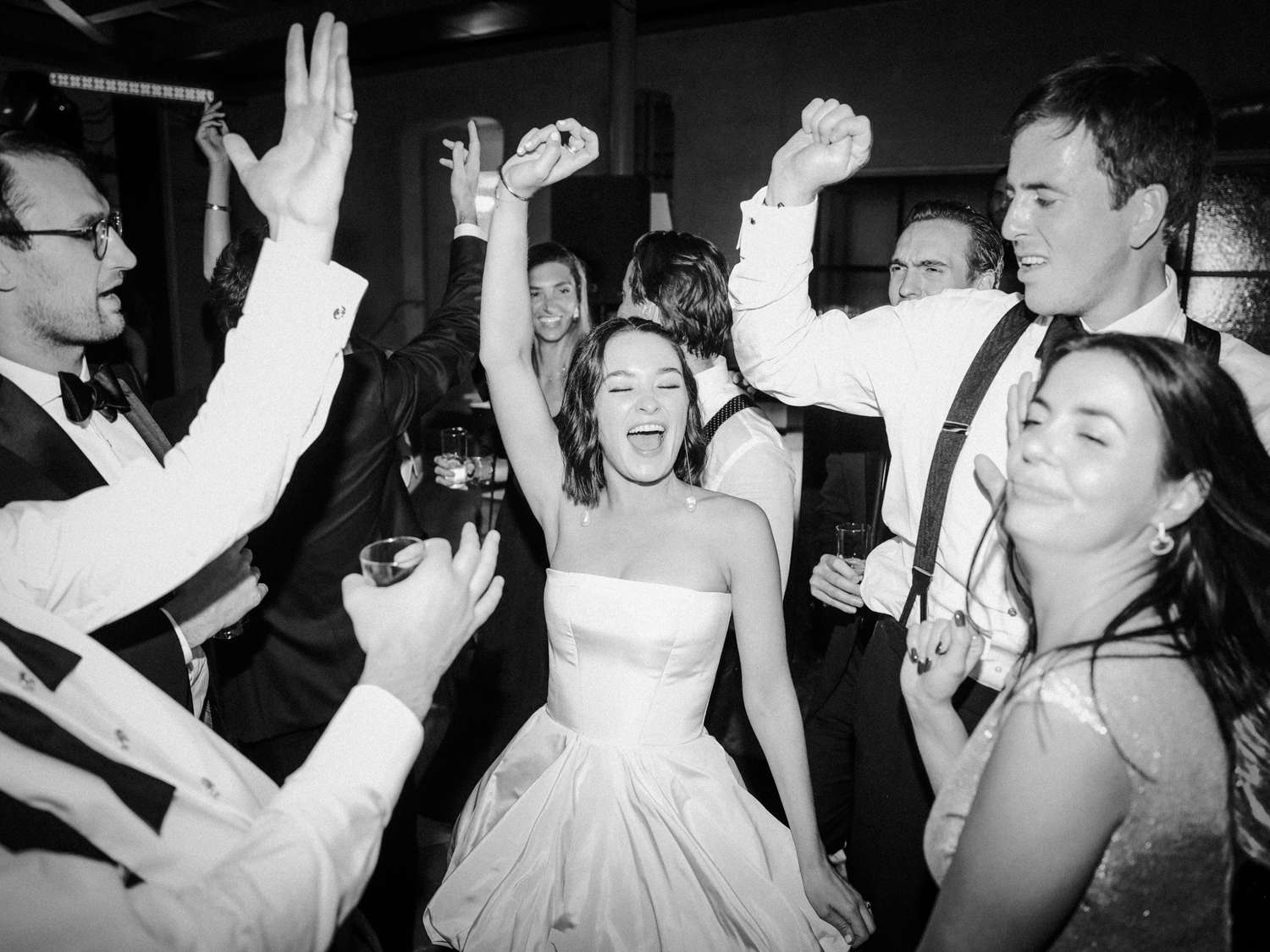 bride wearing off-white strapless vera wang mini dress dancing with guests
