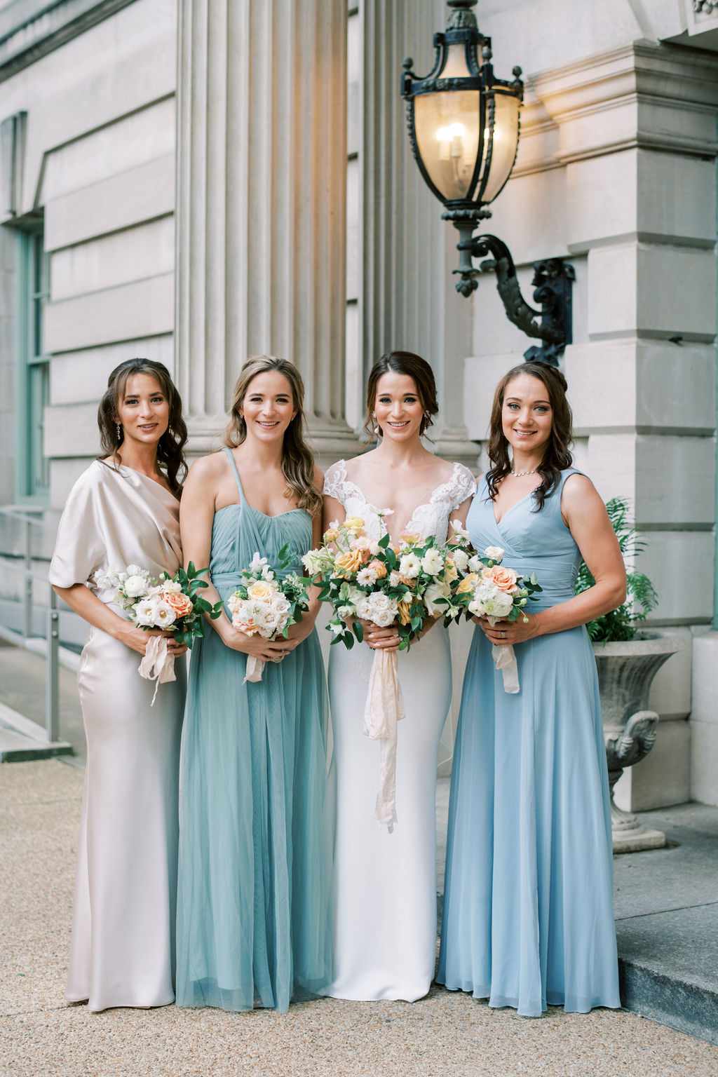 bride standing outside with three bridesmaids