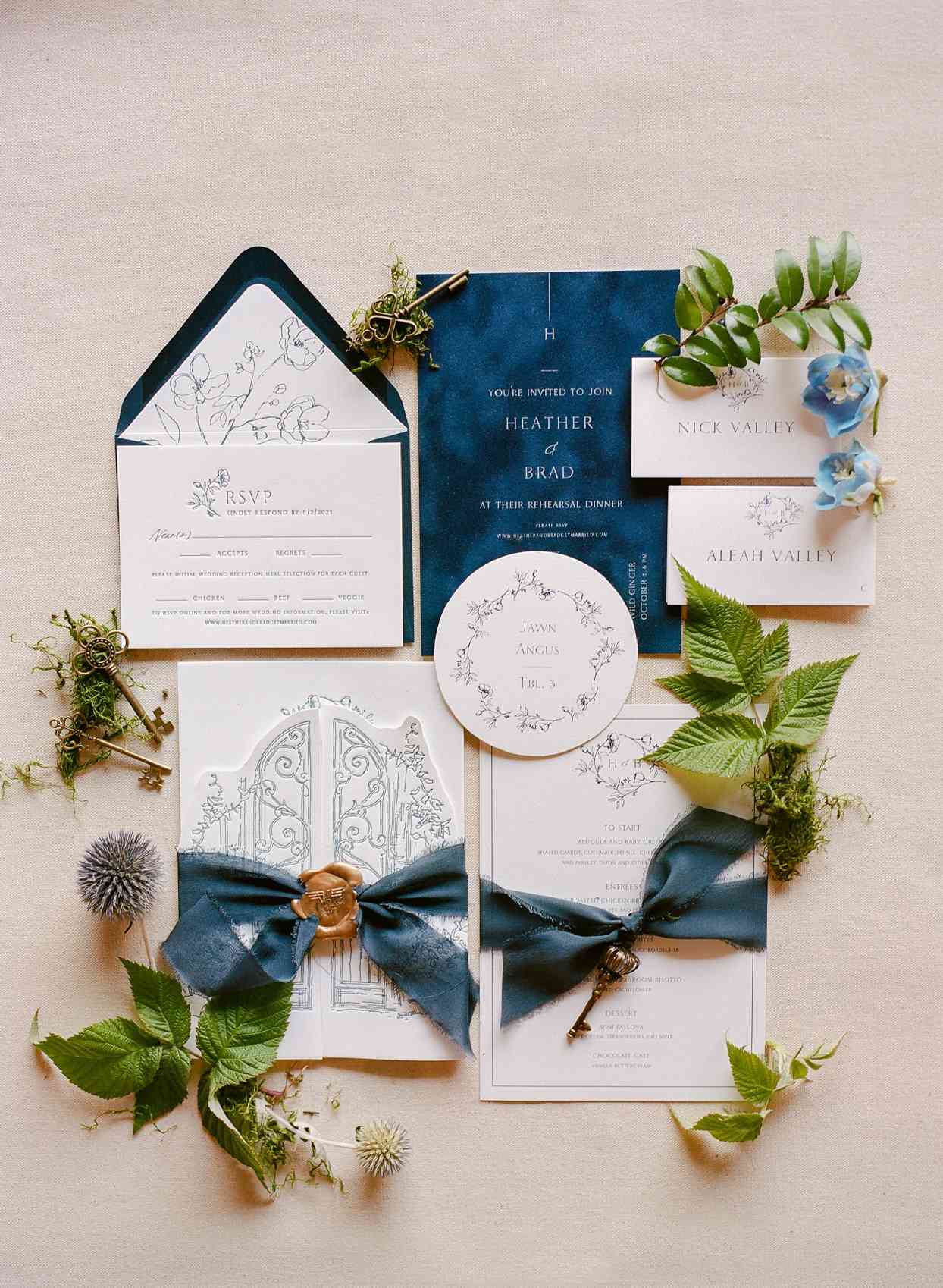 navy blue and white invitation suite with bows and greenery