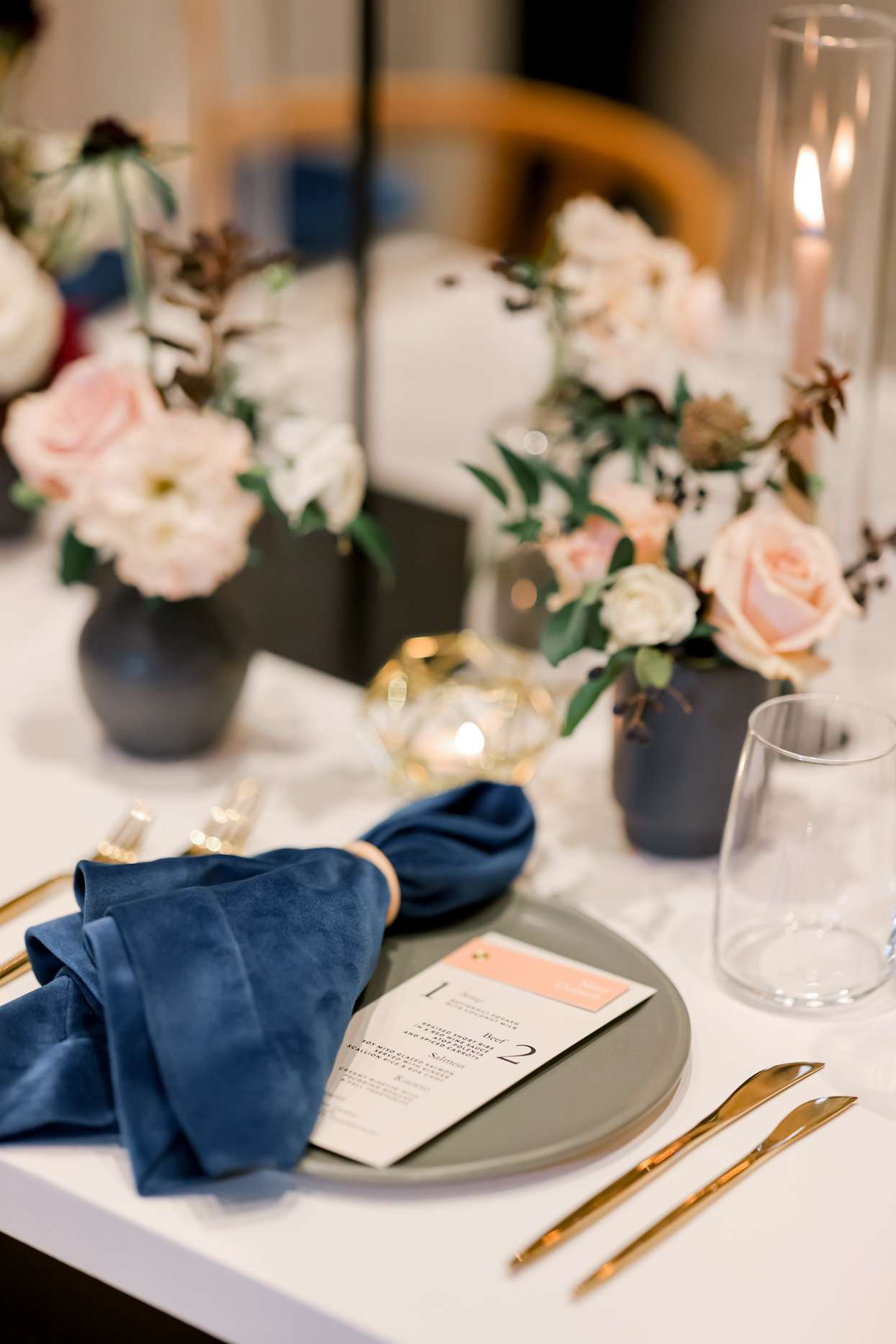 reception table setting with blue napkin and gold utensils