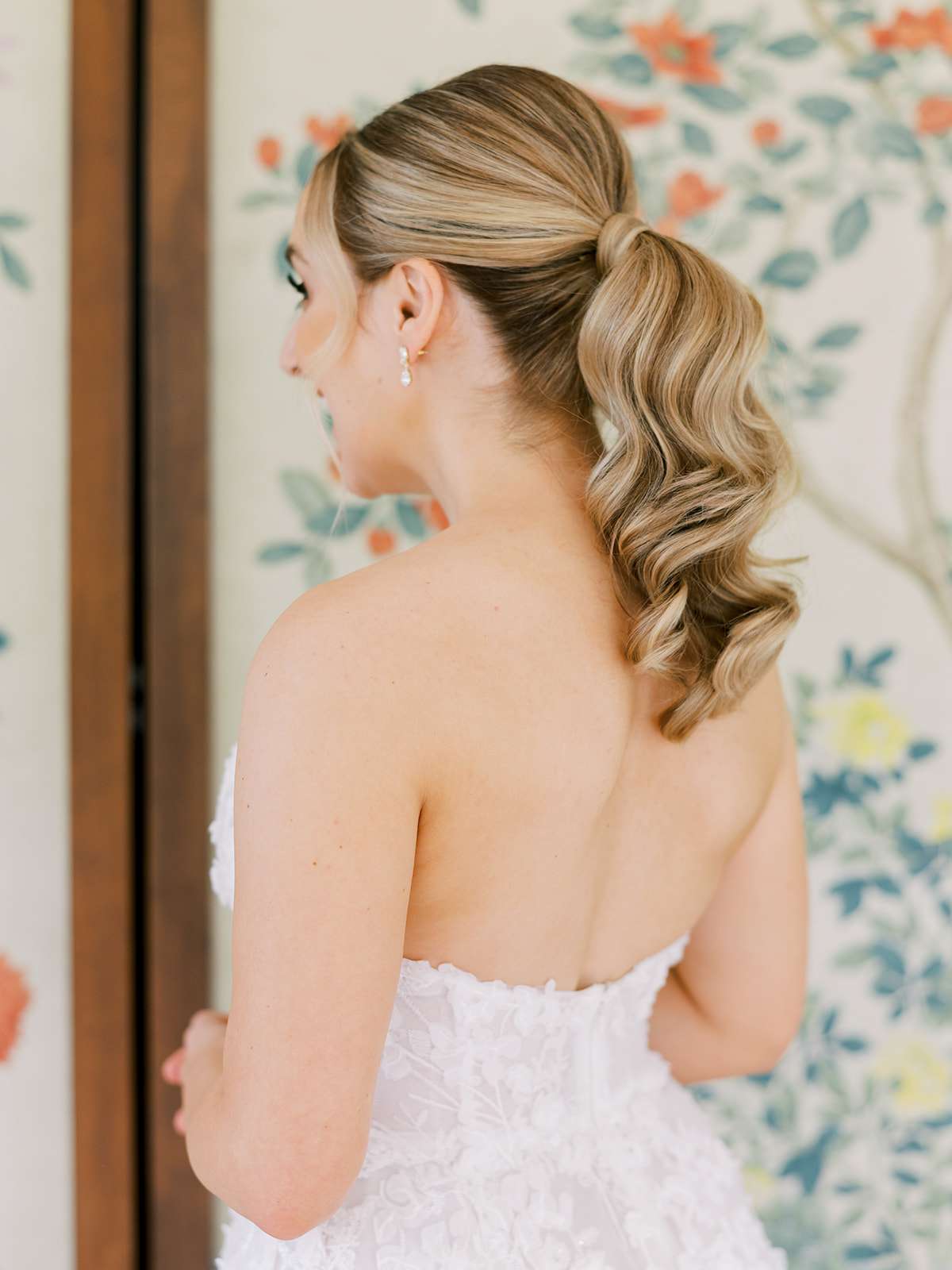 bride with low curled ponytail and strapless dress