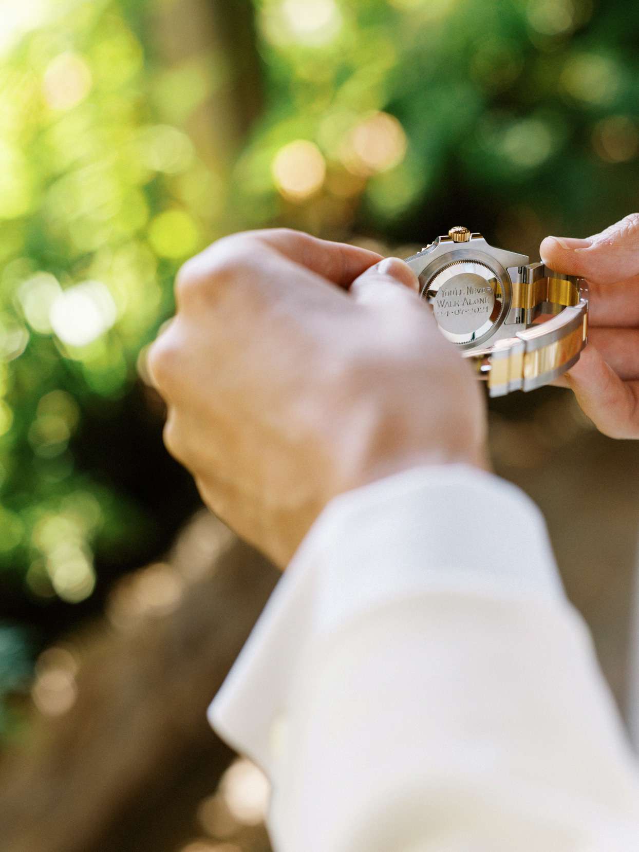 groom holding engraved watch