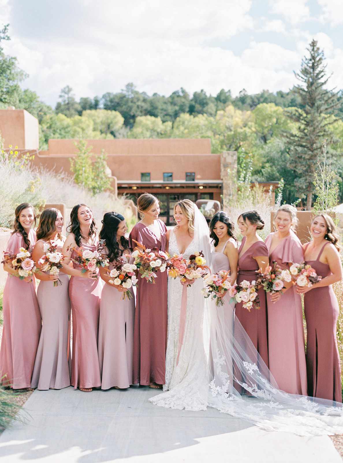 bride with bridesmaids wearing mismatched pink dresses