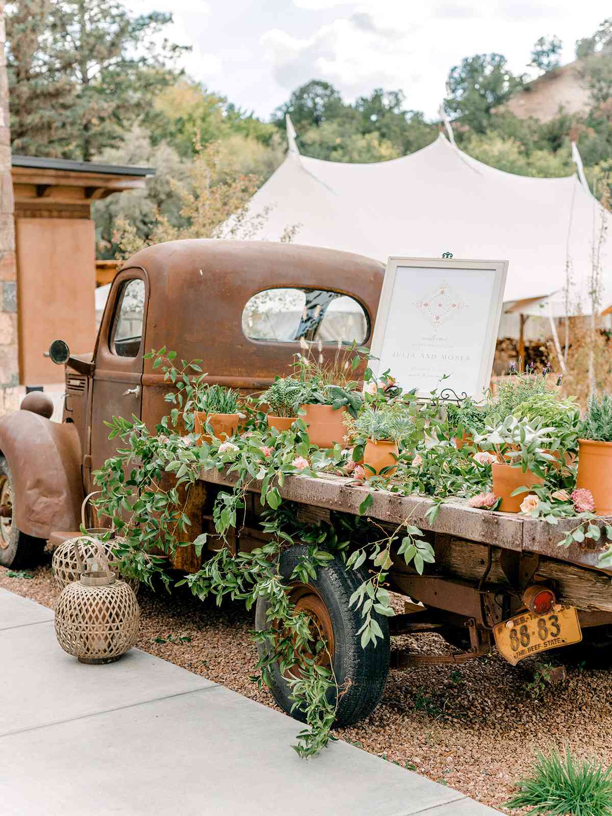 welcome sign displayed on antique truck bed overflowing with greenery