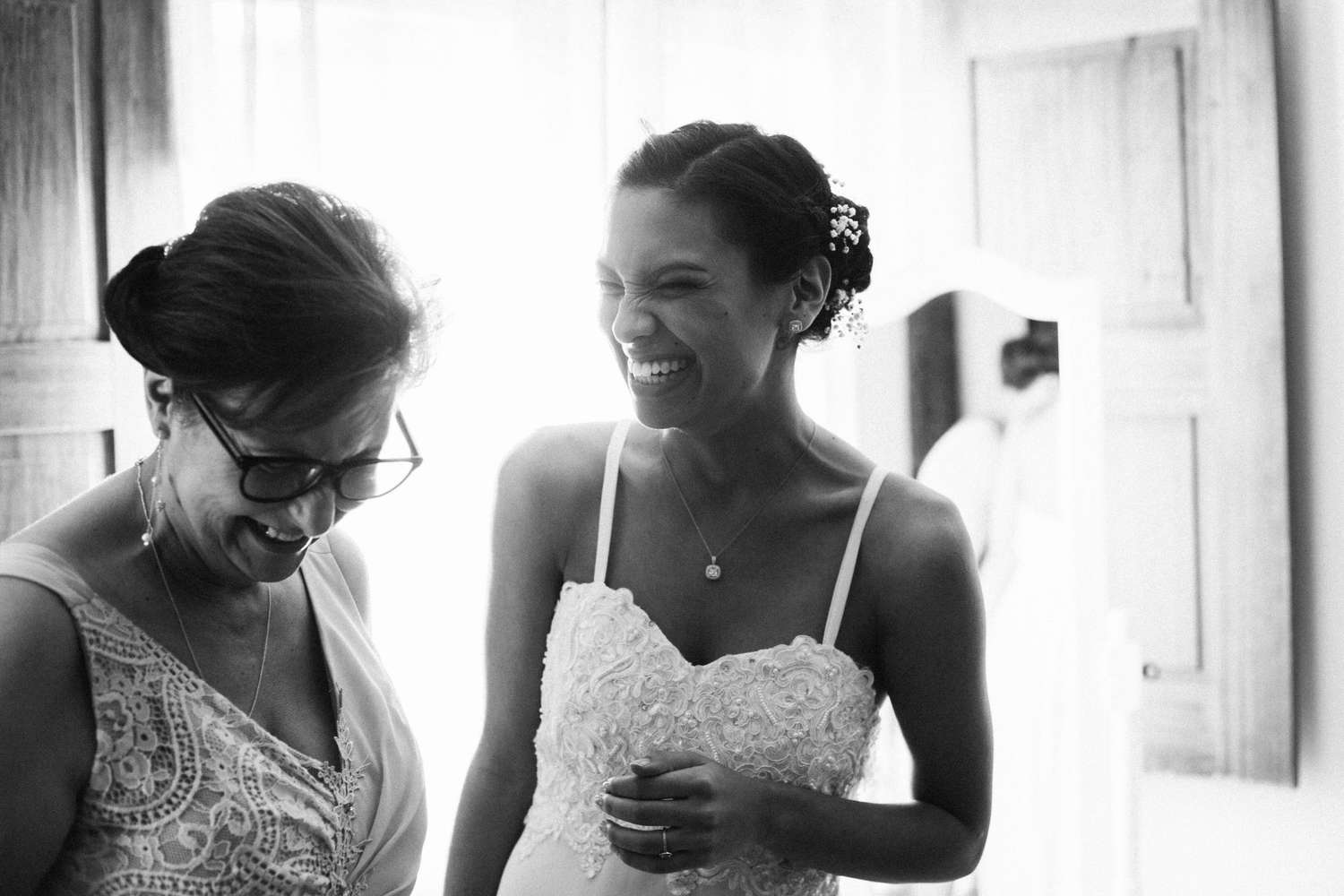 bride laughing with mother on wedding day