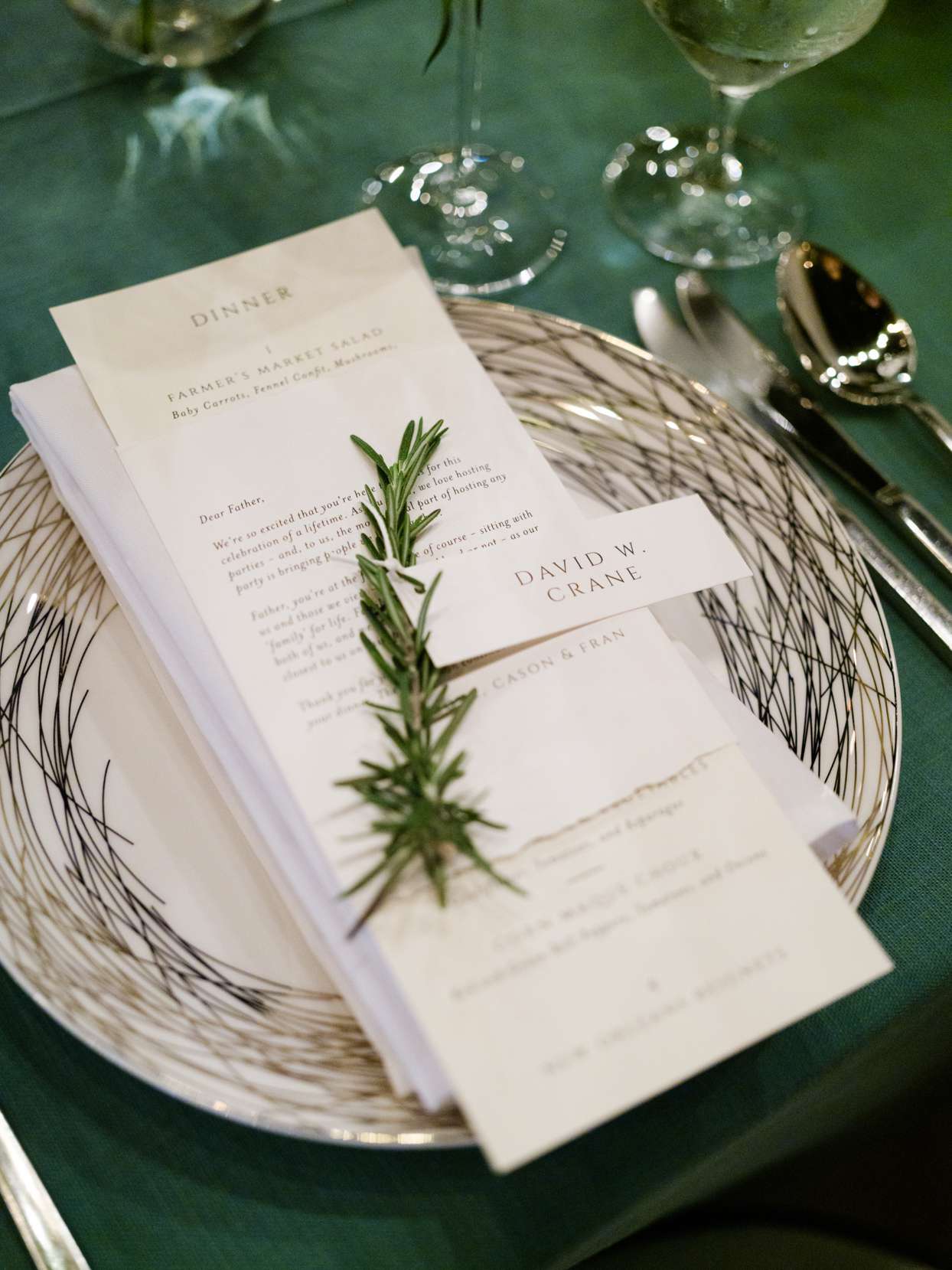 reception place setting with guests name and menu with rosemary sprig