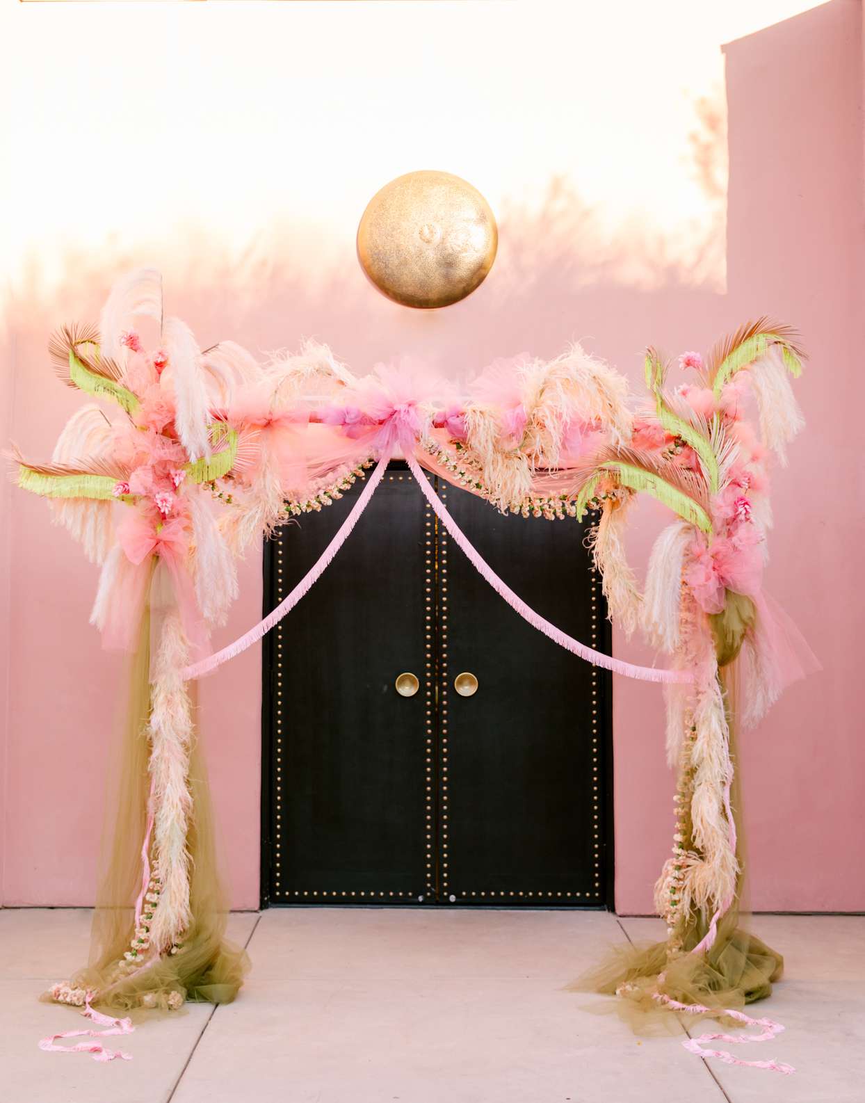 pink feather wedding arch with black doors
