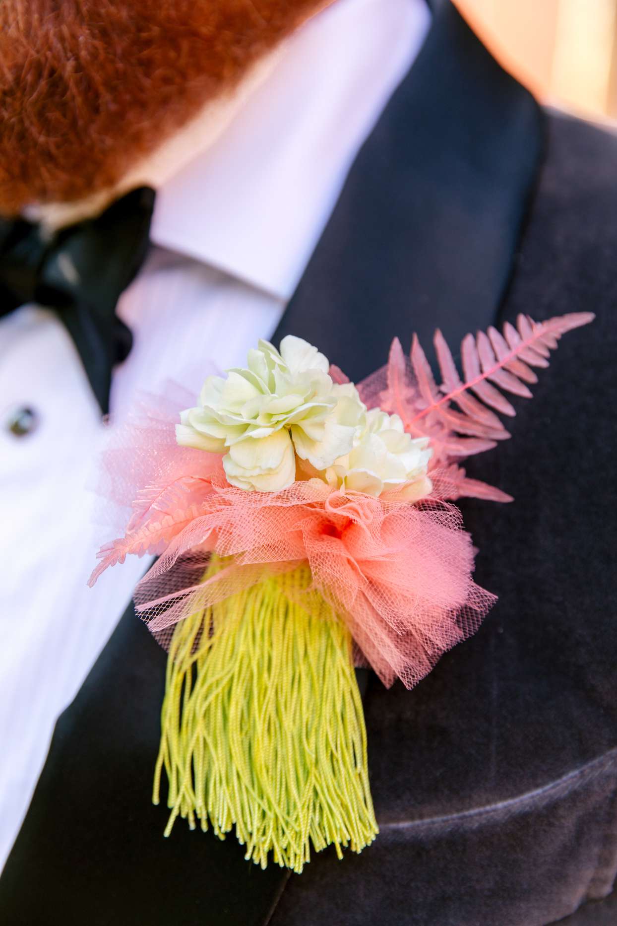 groom boutonniere with a white flower and pink tulle