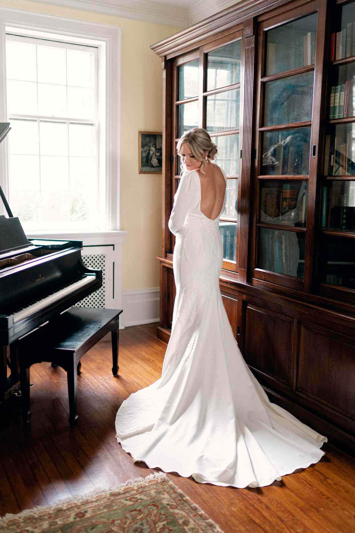 bride wearing long sleeve open back trumpet wedding dress